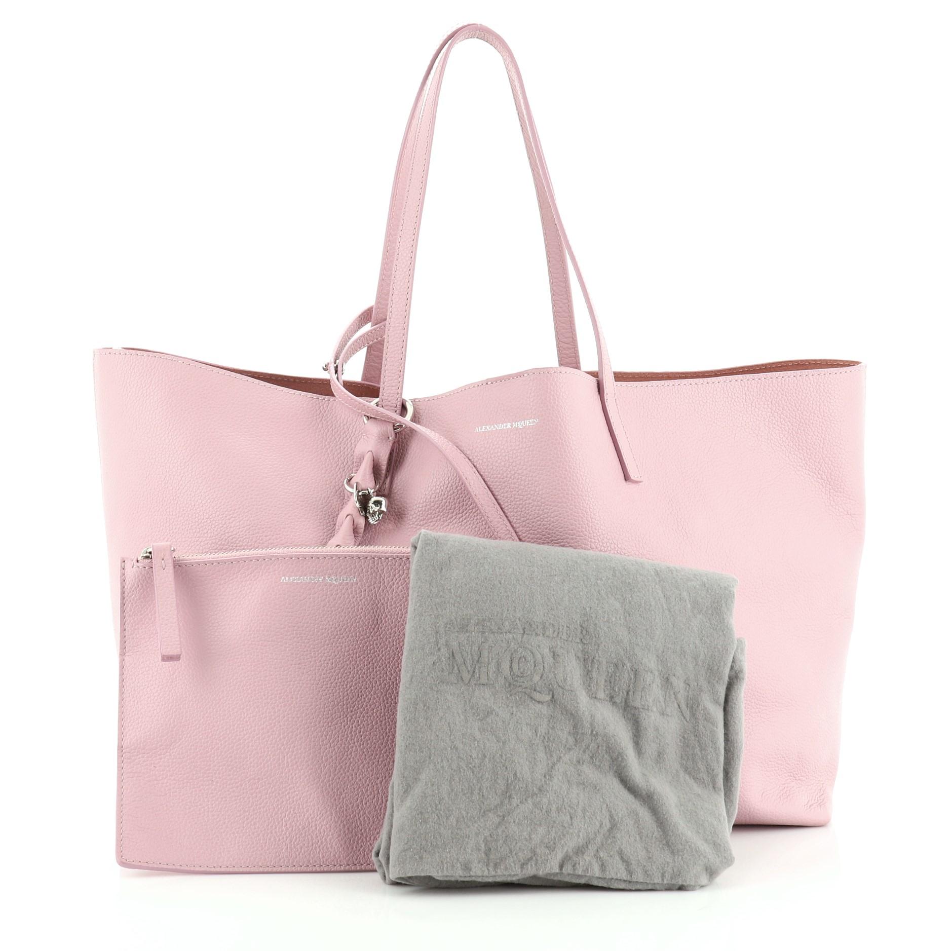 This Alexander McQueen Skull Open Shopper Tote Leather Large, crafted in pink leather, features dual flat leather handles, signature silver skull padlock, and silver-tone hardware. Its wide-open top opens to a pink suede interior. 

Estimated Retail