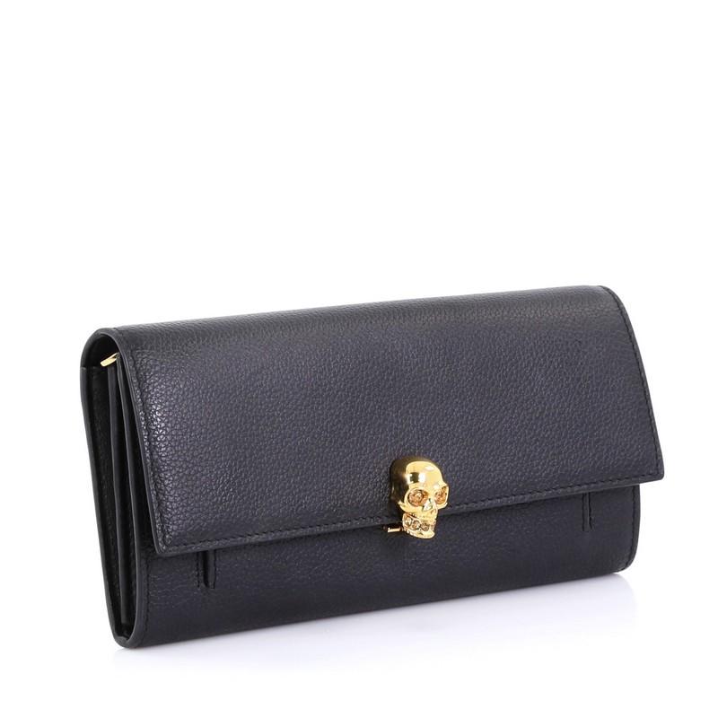 This Alexander McQueen Skull Wallet on Chain Leather Small, crafted in black leather, features chain link strap, signature skull embellishment, and gold-tone hardware. Its skull clasp closure opens to a black leather interior with slip and zip