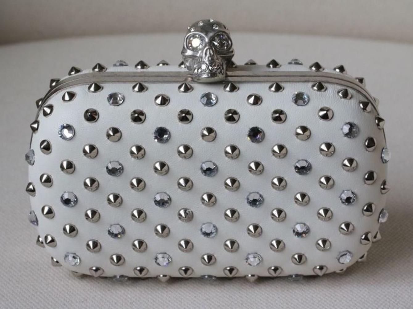Alexander McQueen napa leather clutch with silvertone studs and crystals. Signature hinged crystal-embellished skull clasp. Framed hard-shell design with rounded corners. Made in Italy.

Dimensions: Approx. 14 x 9 x 5 cm 

Condition: As new