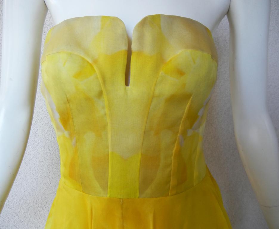 Stunning Alexander McQueen gown in layers of silk organza.   Strapless fitted bodice extends into a voluminous ballgown skirt.   Designed in a rich daffodil yellow ground overlaid in a large floral poppy pattern.  A vintage piece not easily
