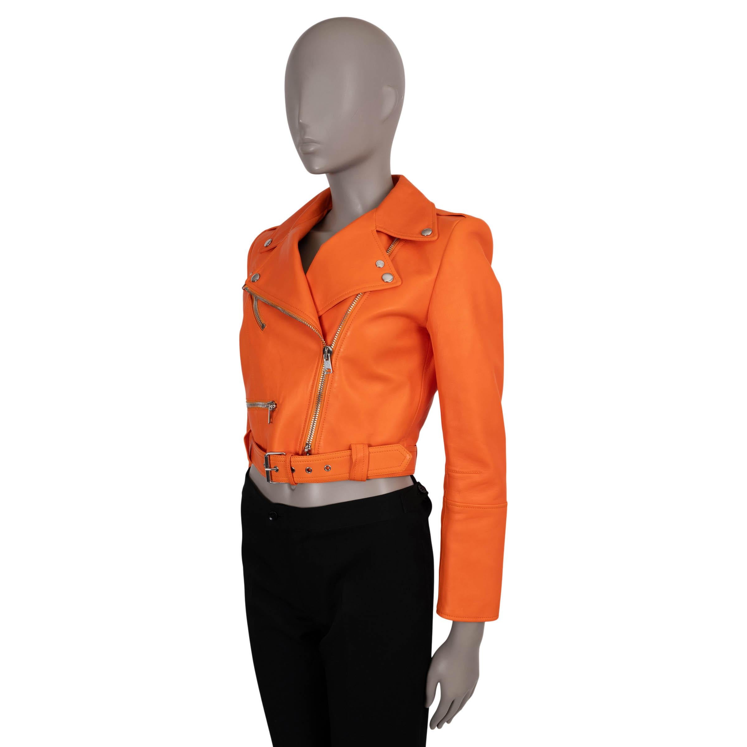 This 100% authentic Alexander McQueen biker jacket is crafted in sunset orange lambskin leather, offering a bold take on the classic biker silhouette. The cropped design features notched lapels with snap buttons, two zippered pockets, and zipped