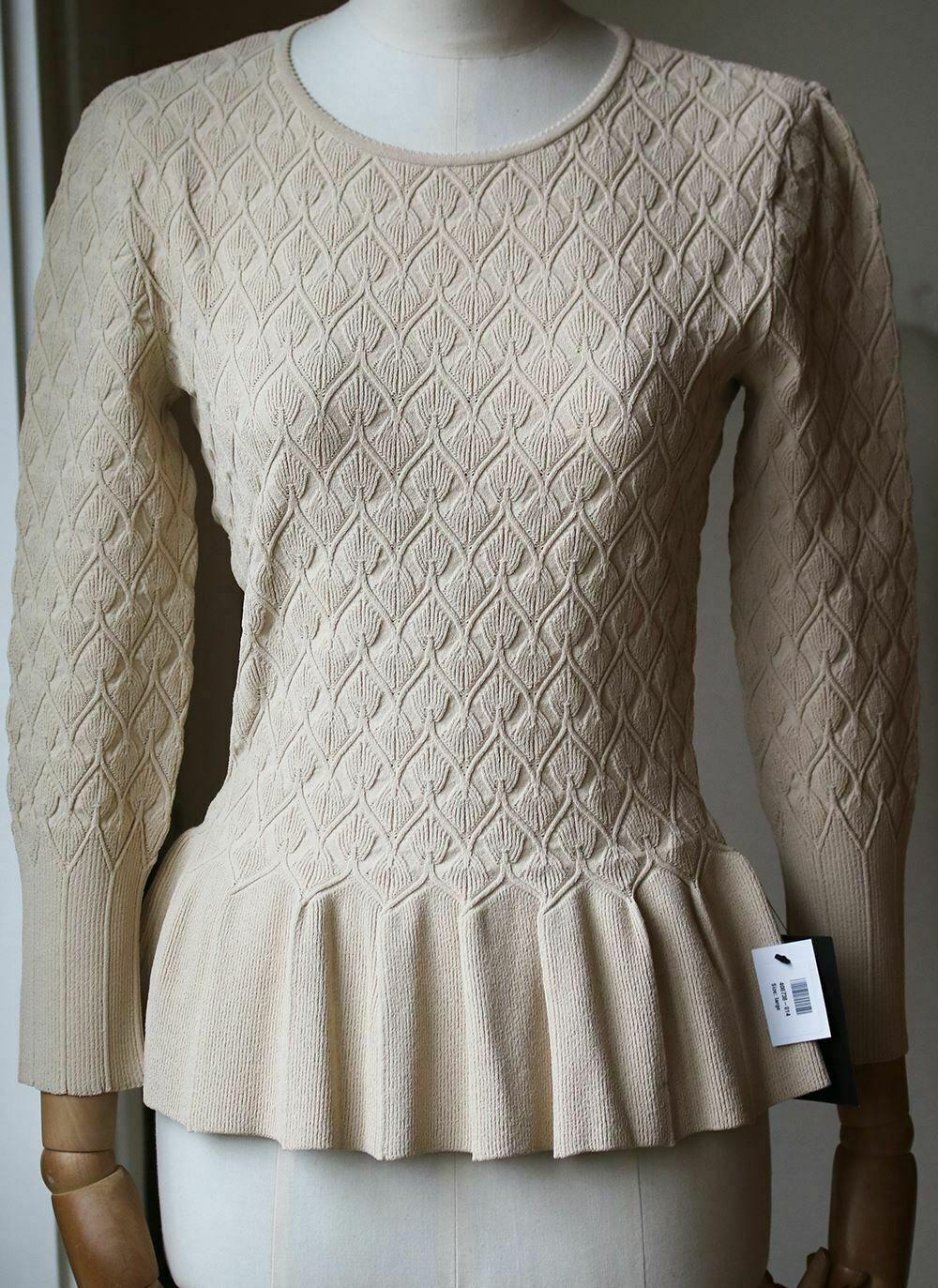 Alexander McQueen's knitted cream top has a flared peplum that creates the illusion of a cinched-in waist. Alexander McQueen cream top. Textured mid-weight viscose-blend. Peplum, ribbed trims. Slips on. 75% viscose, 25% polyester.

Size: Large (UK