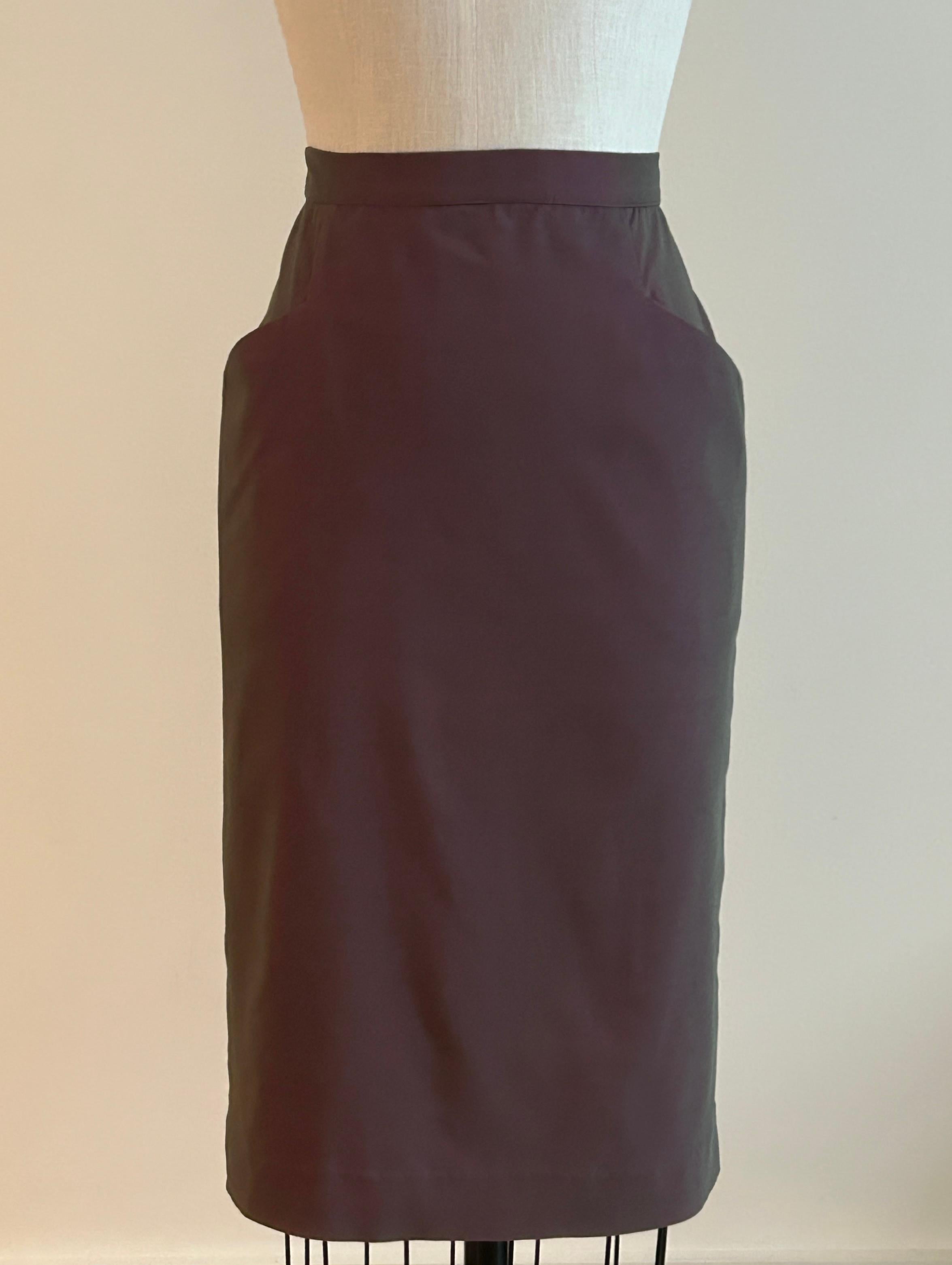 Vintage Alexander McQueen pencil skirt in an interwoven red and black textile that almost has a slight irredescent quality. The color reads like a grayish red. Pockets at front sides. Slit at center back. Back zip and button closure.

49% polyamide,