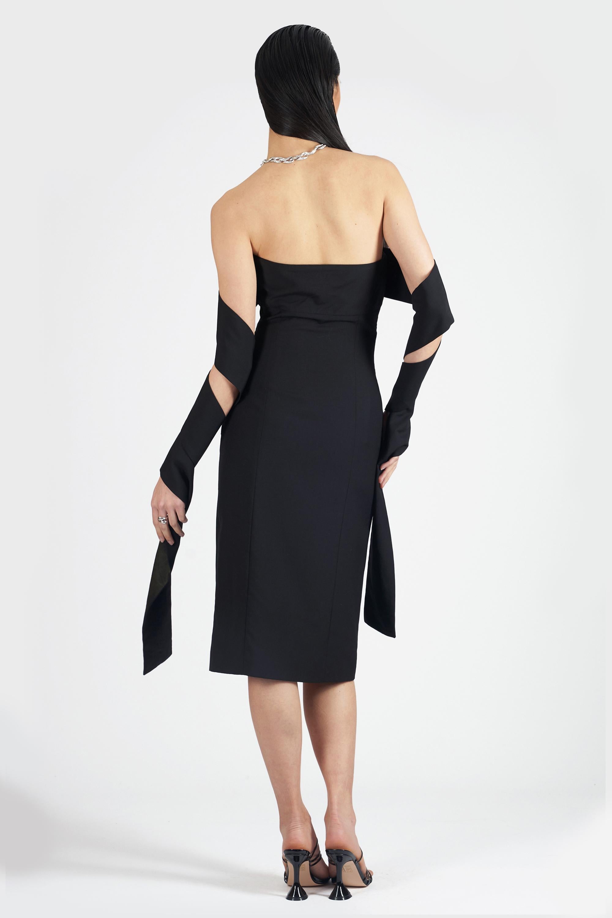 We are incredibly excited to present this rare Alexander McQueen Spring Summer 2001 ‘Voss’ collection strapless black dress. Features bandeau neckline, arm sash, zip side closure and midi length. In excellent vintage condition. Authenticity