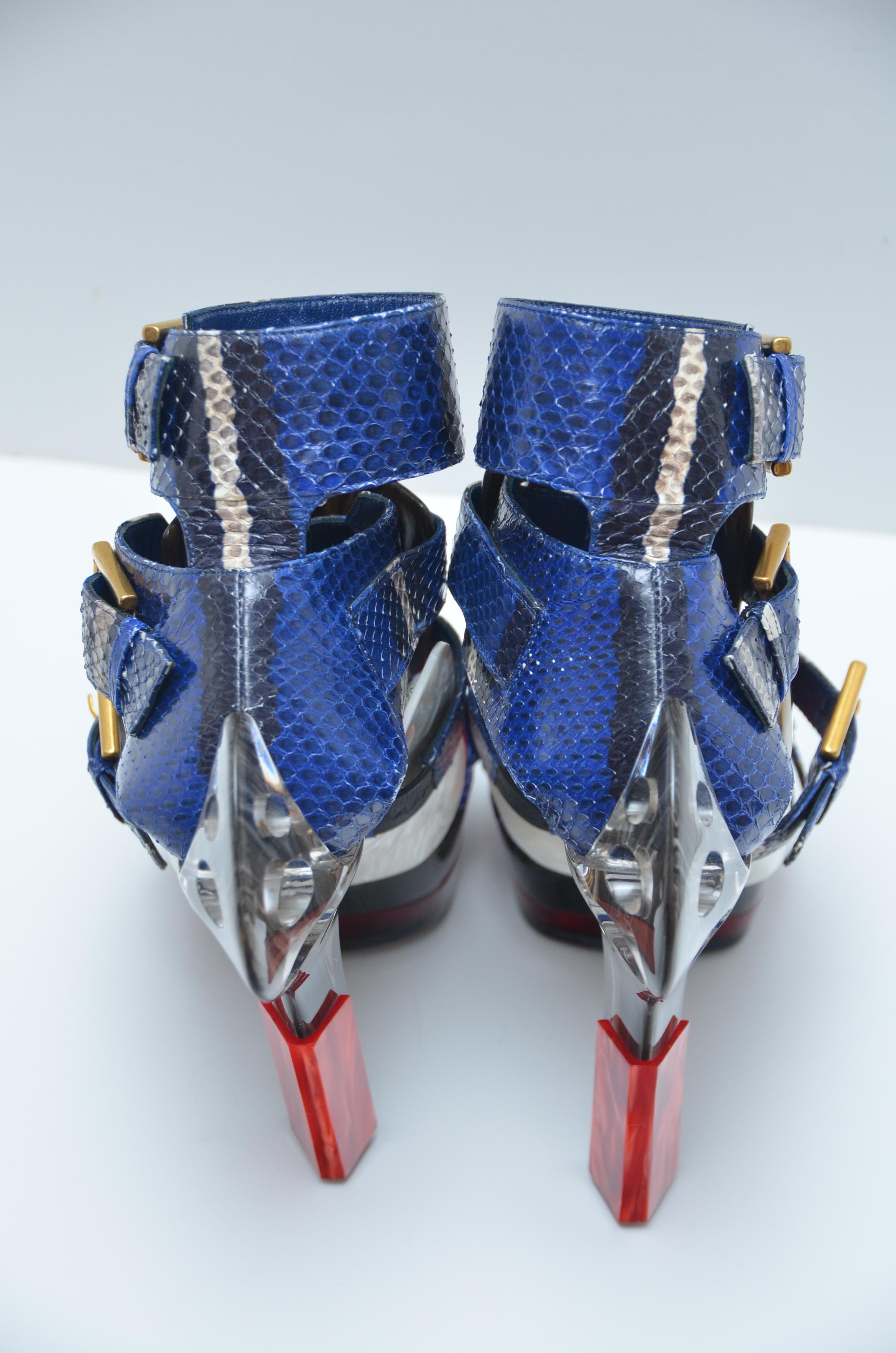 From the Spring 2014 Collection. 
Blue and multicolor python Alexander McQueen Maya platform sandals with marbled resin panels throughout, cutout details at counters, resin heels and gold-tone buckle closures at straps. 
Original price was around
