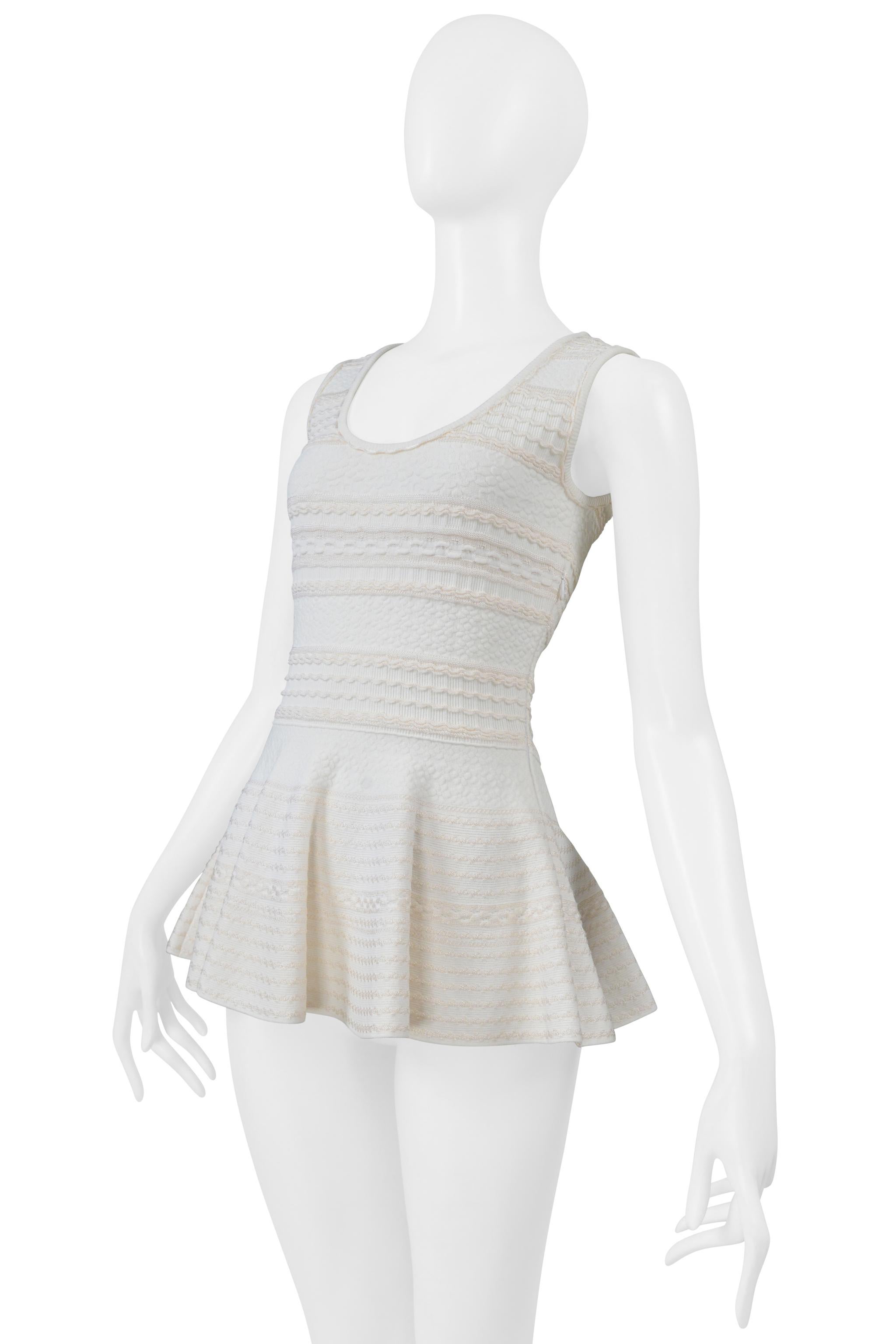 Resurrection Vintage è lieta di offrirti un top in maglia peplo Alexander McQueen bianco e crema, caratterizzato da scollo rotondo, dettagli ricamati, cerniera laterale nascosta e design senza maniche. 
Alexander McQueen
Fabrice: 83% Viscosa, 17%