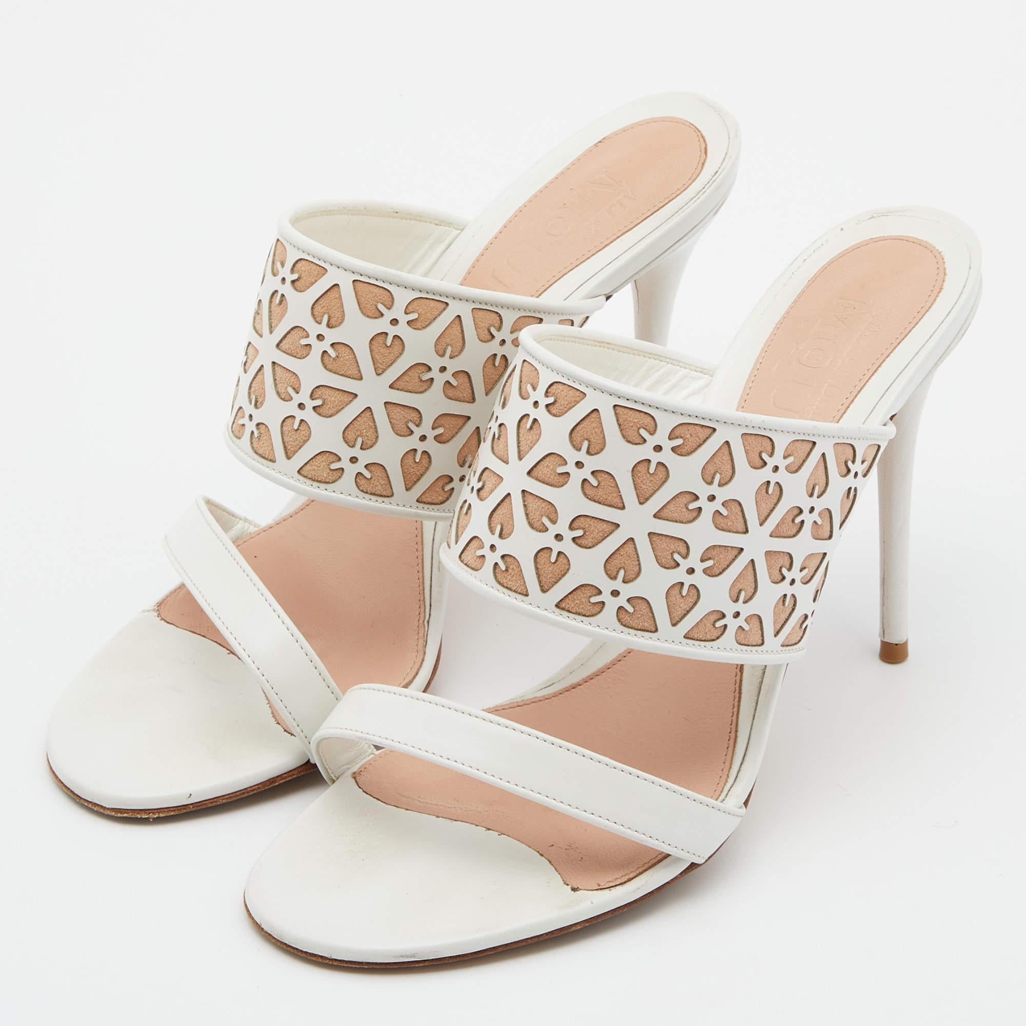 These feminine white and beige sandals by Alexander McQueen are simply stunning. Made from leather  they feature a laser cut design on the broad straps  open toes  and 10.5 cm heels. Match them with any outfit for a polished finish.