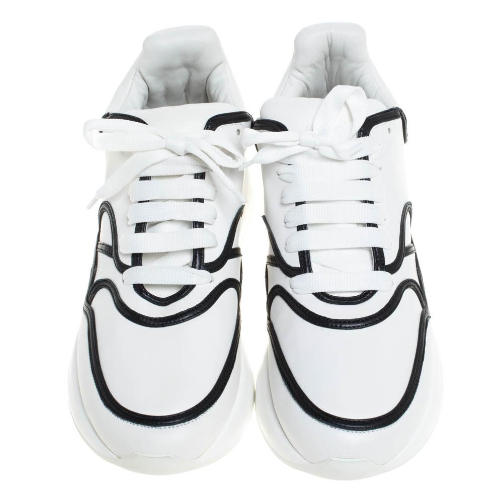 Let your latest shoe addition be this pair of sneakers from Alexander McQueen. These white sneakers have been crafted from leather and feature black trims detailed on the uppers. They flaunt round toes, tie-up fastenings and brand logos on the heel