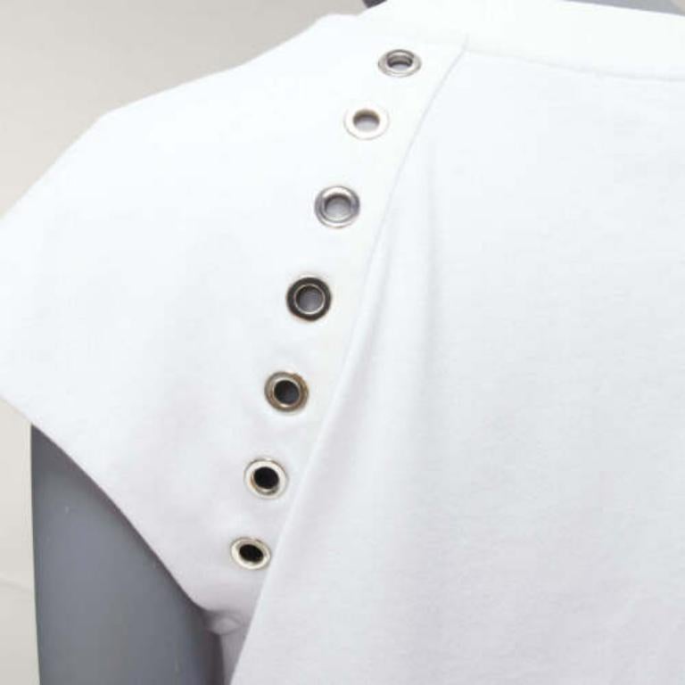 ALEXANDER MCQUEEN detalle ojal de algodón blanco  top de manga larga con tachuelas  IT38 XS
Referencia: AAWC/A00668
Marca: Alexander McQueen
Diseñadora: Sarah Burton
Colección: 2022
Material: Algodón, Metal
Color: Blanco, Plata
Patrón: