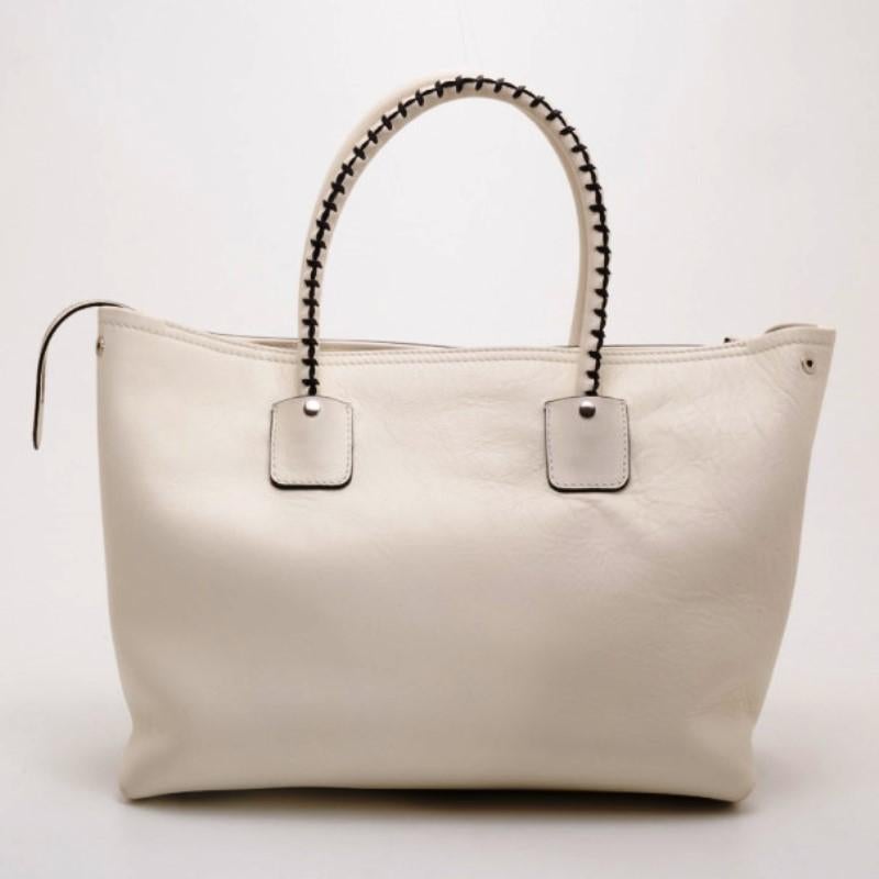 This Alexander McQueen White Folkstitch tote is just what every city girl needs. Crafted from crisp white leather, it is beautifully detailed with brown stitching, a front zip pocket, tassels, leather ID tag and rolled leather handles. The interior