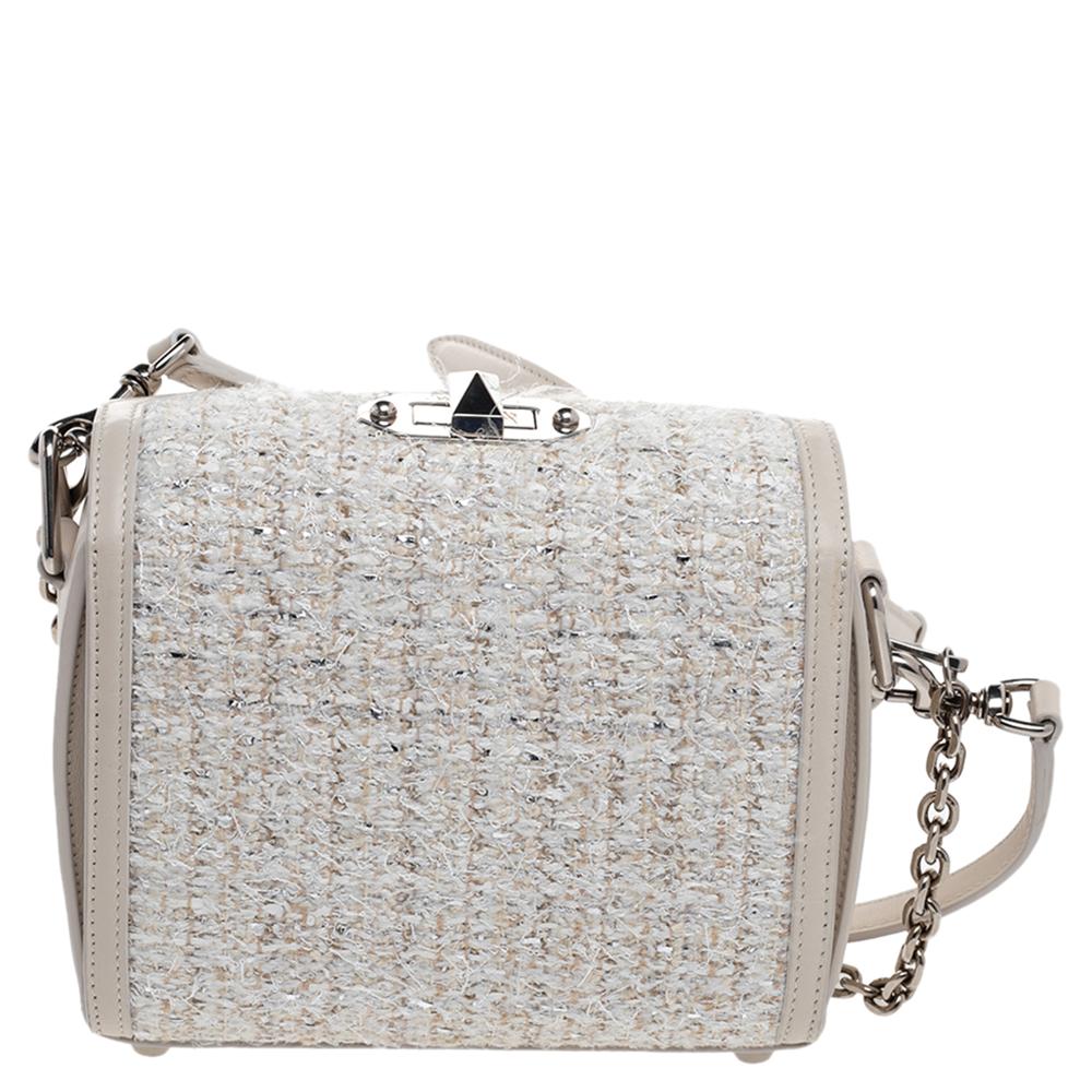 This Box crossbody bag from Alexander McQueen exhibits a beautiful white tweed and leather exterior and silver-toned metal fittings. The suede interior can easily carry all your belongings. This Alexander McQueen handbag is just what you need to