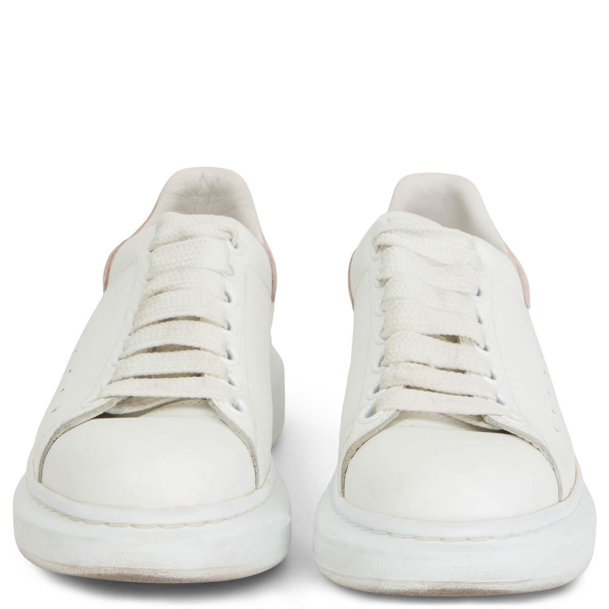 100% authentic Alexander McQueen oversized sneakers in white leather with a chunky rubber sole that features a built-in wedge for height and comfort. The heel is pale pink suede and printed with the designer's logo. Have been worn with some soft