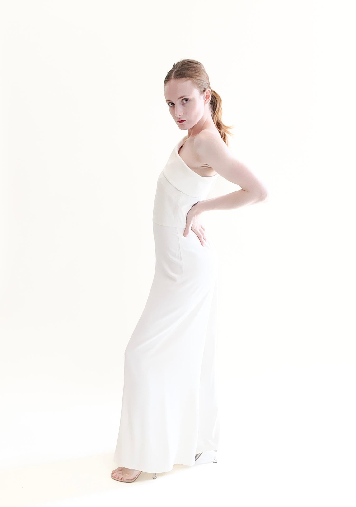 Step into style with the Alexander McQueen White One Shoulder Jumpsuit. This stunning piece is the perfect addition to your wedding week activities, including a bridal brunch or luncheon. The one shoulder asymmetric neckline with a tied bow adds a