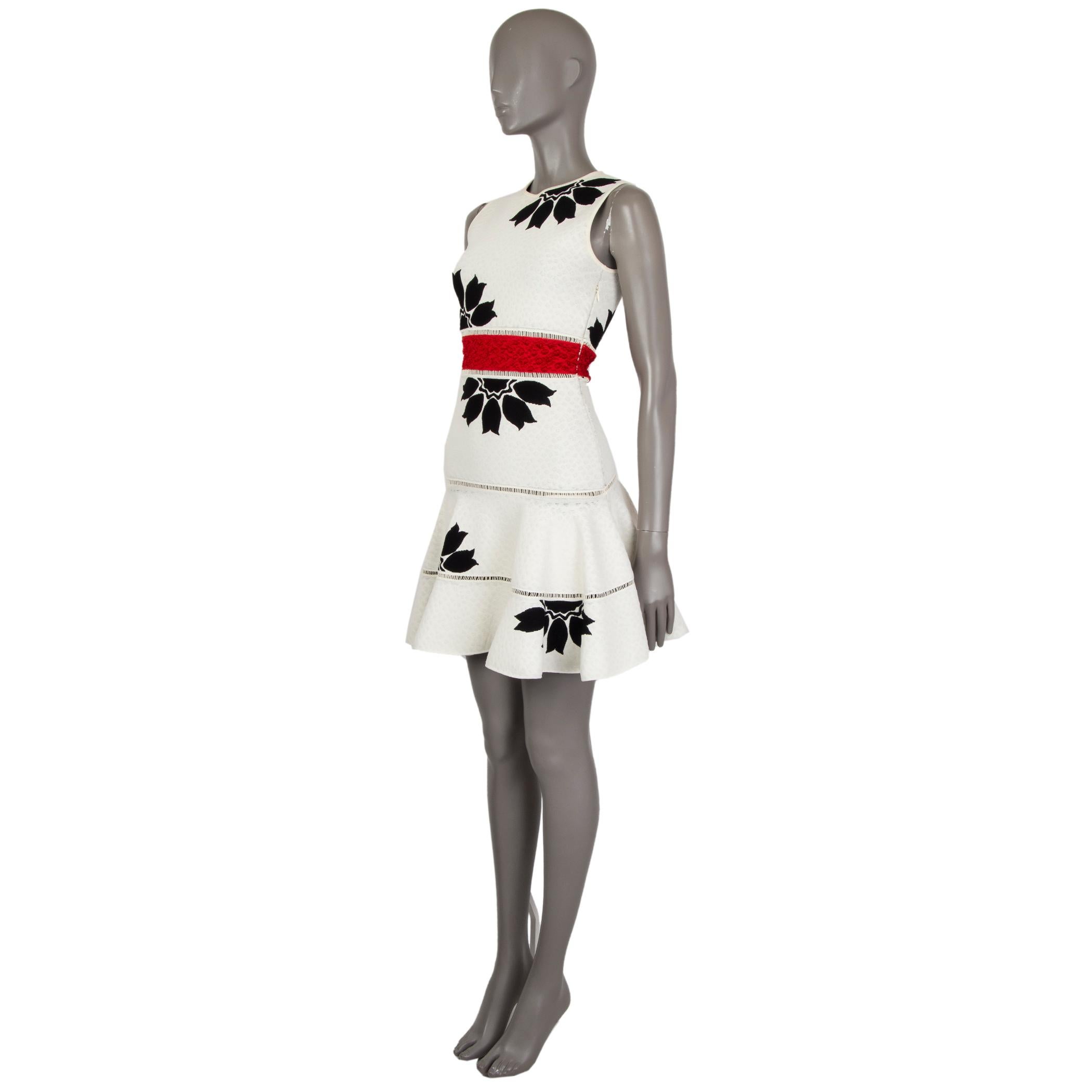 Alexander McQueen floral jacquard-knit dress in cream and black viscose (83%) and polyester (17%). With embroidered waistband in red acetate (63%), viscose (31%), and polyester (6%). Features a crew neck and flared skirt. Closes with invisible
