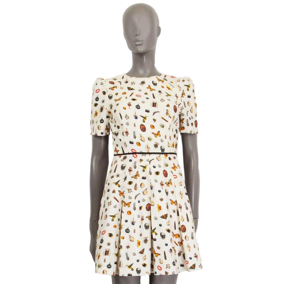 authentic Alexander McQueen Obsession-print dress from 2016 in cream and multi-color viscose (100%) with a pleated bottom, padded shoulders and short sleeves. Lined in cream viscose (50%) cotton (50%). Closes with a concealed zipper in the back. Has