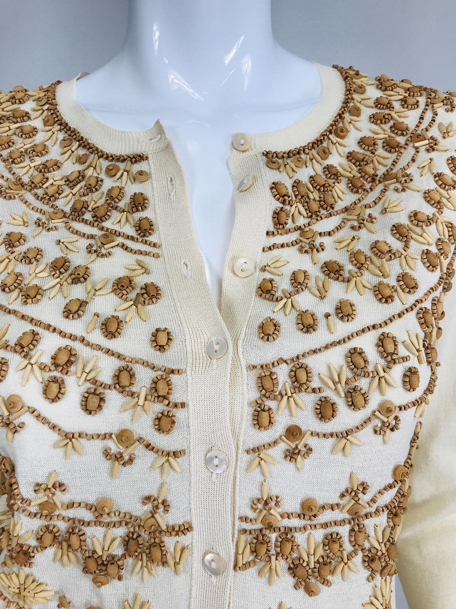 Alexander McQueen wooden beaded cream silk & cotton cardigan sweater. Beautiful 50/50 silk & cotton sweater in soft cream the front is sewn with assorted natural wooden beads in a beautiful design. Ribbed neck, cuffs and hem. 3/4 length sleeves.