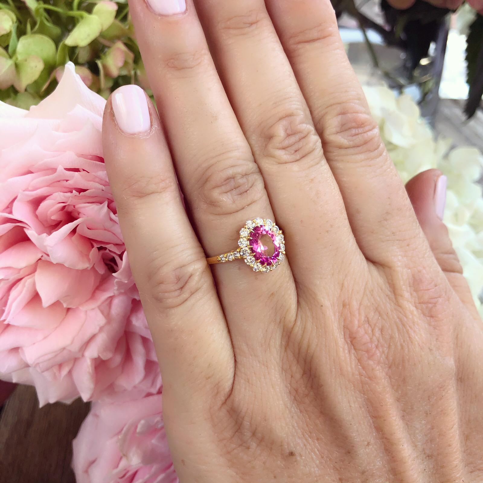 By noted French jewelry Alexander Reza, this gorgeous 18k yellow gold ring features an oval-shaped Madagascar unheated bright and intriguing pink sapphire weighing 1.90 carats, surrounded by 20 round brilliant-cut diamonds, G/VS, totaling 0.65