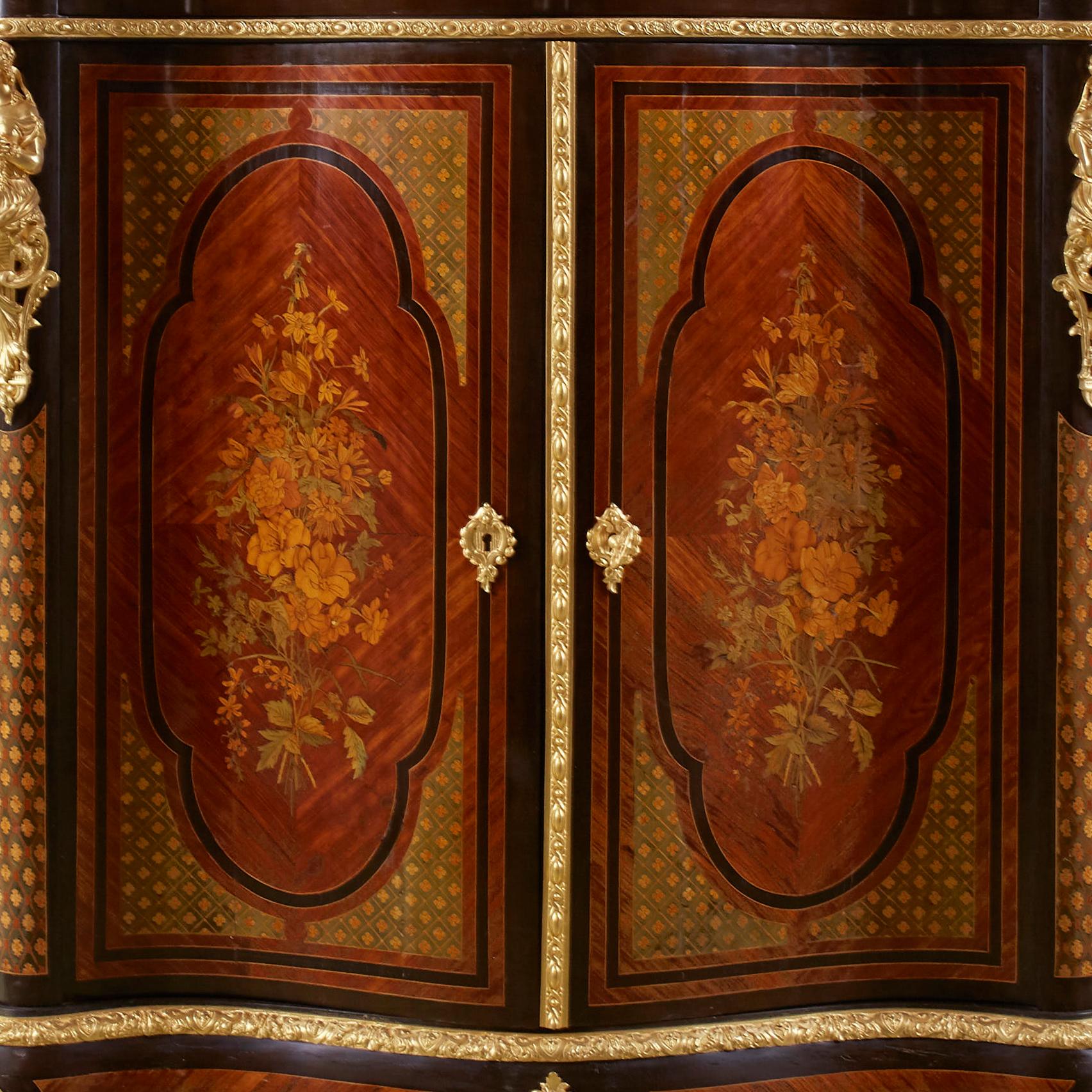 Alexander Roux Serpentine Inlaid Side Cabinet’ uses mainly light wood materials such as kingwood or satinwood, and floral motifs to bring a feeling of closeness, friendliness towards nature. The background texture has a classic trellis lattice
