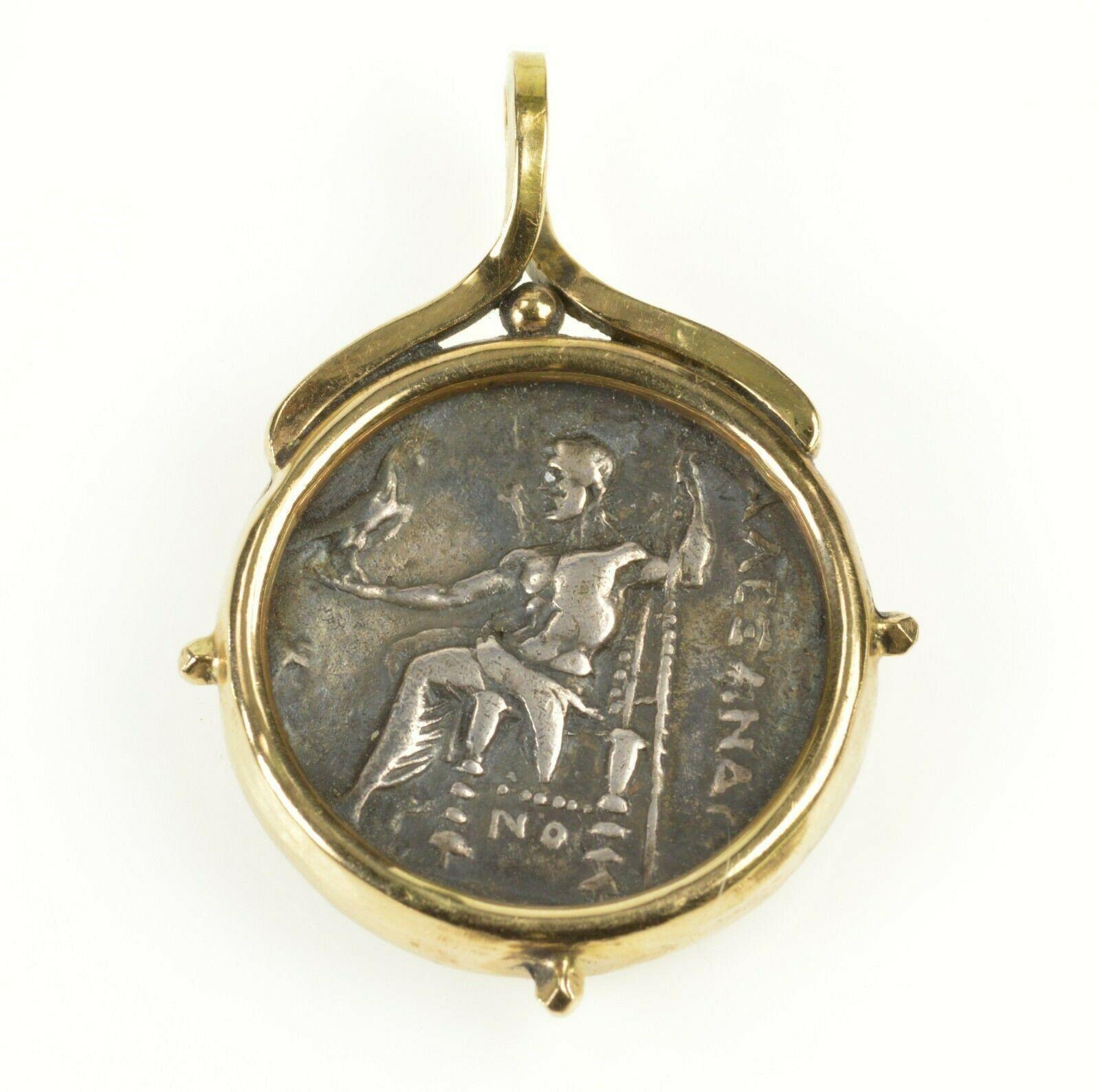 Alexander The Great Authentic Greek Coin Pendant set in 14k yellow gold weighing 22.9 grams. Coin is struck in silver. 

Coin Inscriptions.
There are two types of inscriptions found on the reverse of Alexander coins. The primary inscription is