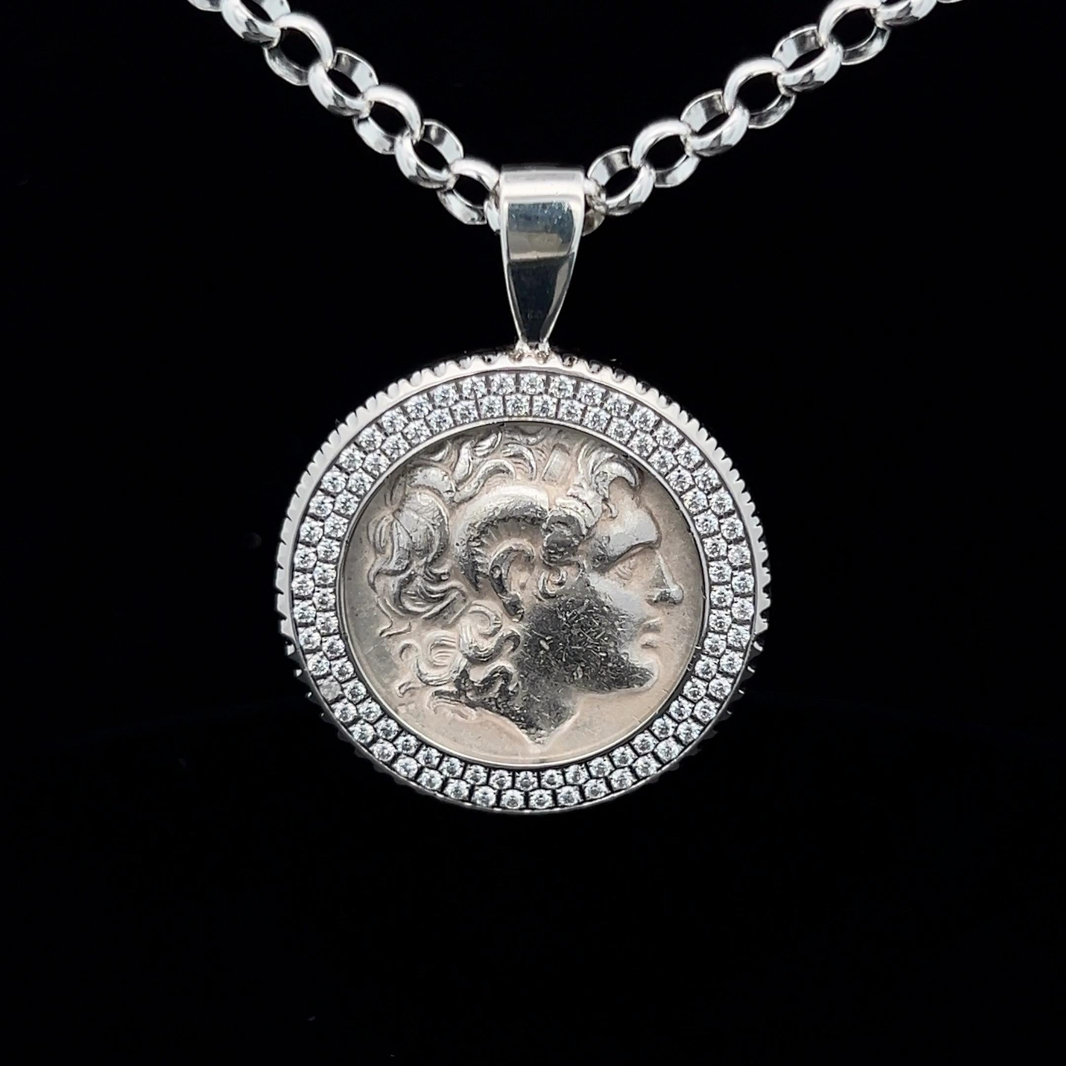 Dieses exquisite Schmuckstück zeigt eine antike griechische Silber-Tetradrachme, die für keinen geringeren als den legendären Alexander den Großen geprägt wurde. Die in einen Kristallrahmen eingefasste Münze ist ein fesselndes Stück, das uns in die