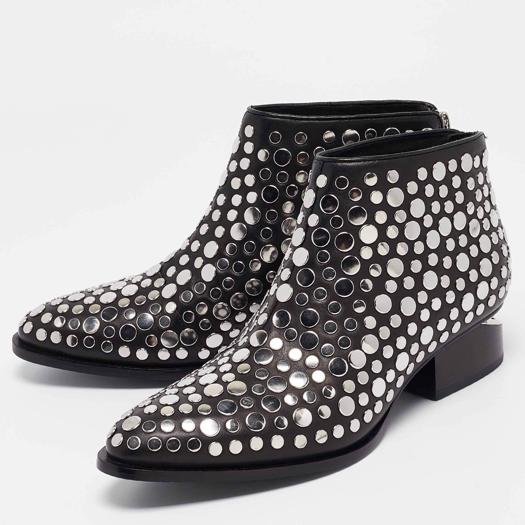 Dansez avec style et éblouissez les foules avec ces fabuleuses bottines signées Alexander Wang. Ces beautés noires ont été confectionnées en cuir et sont ornées de clous sur toute leur surface. Montées sur des talons bien coupés, vous pourrez les