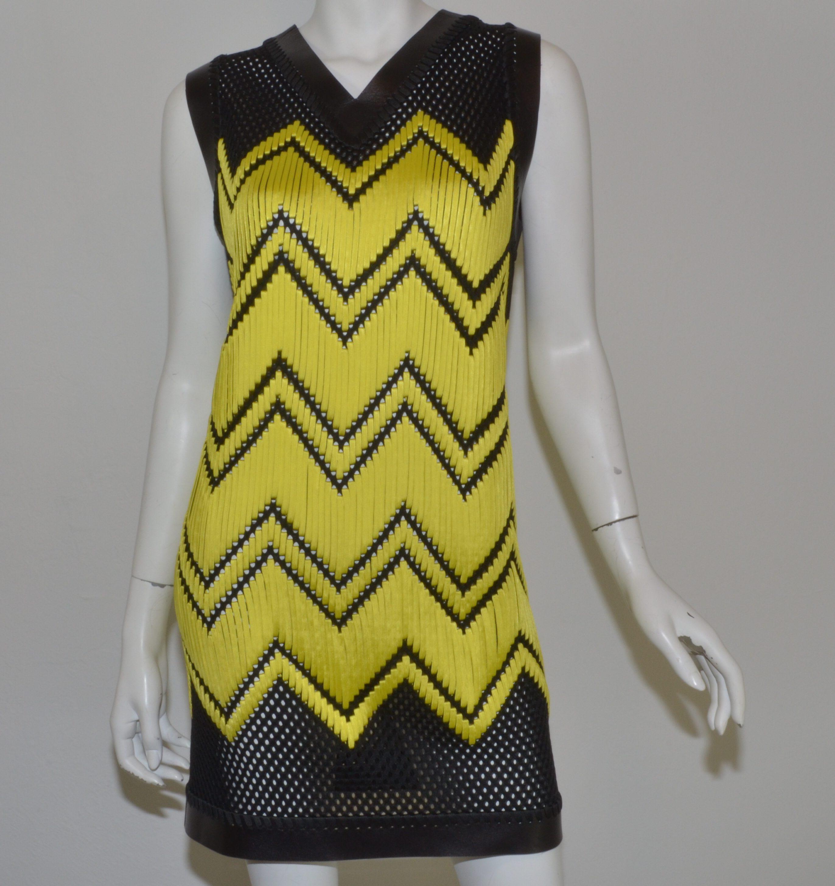 Alexander Wang dress is featured in a black and highlighter-yellow jersey mesh fabric with a chevron design. Dress has a leather-trimmed V-neckline and hem and is labeled a size OS (one size). Dress is composed with 100% polyester and lambskin