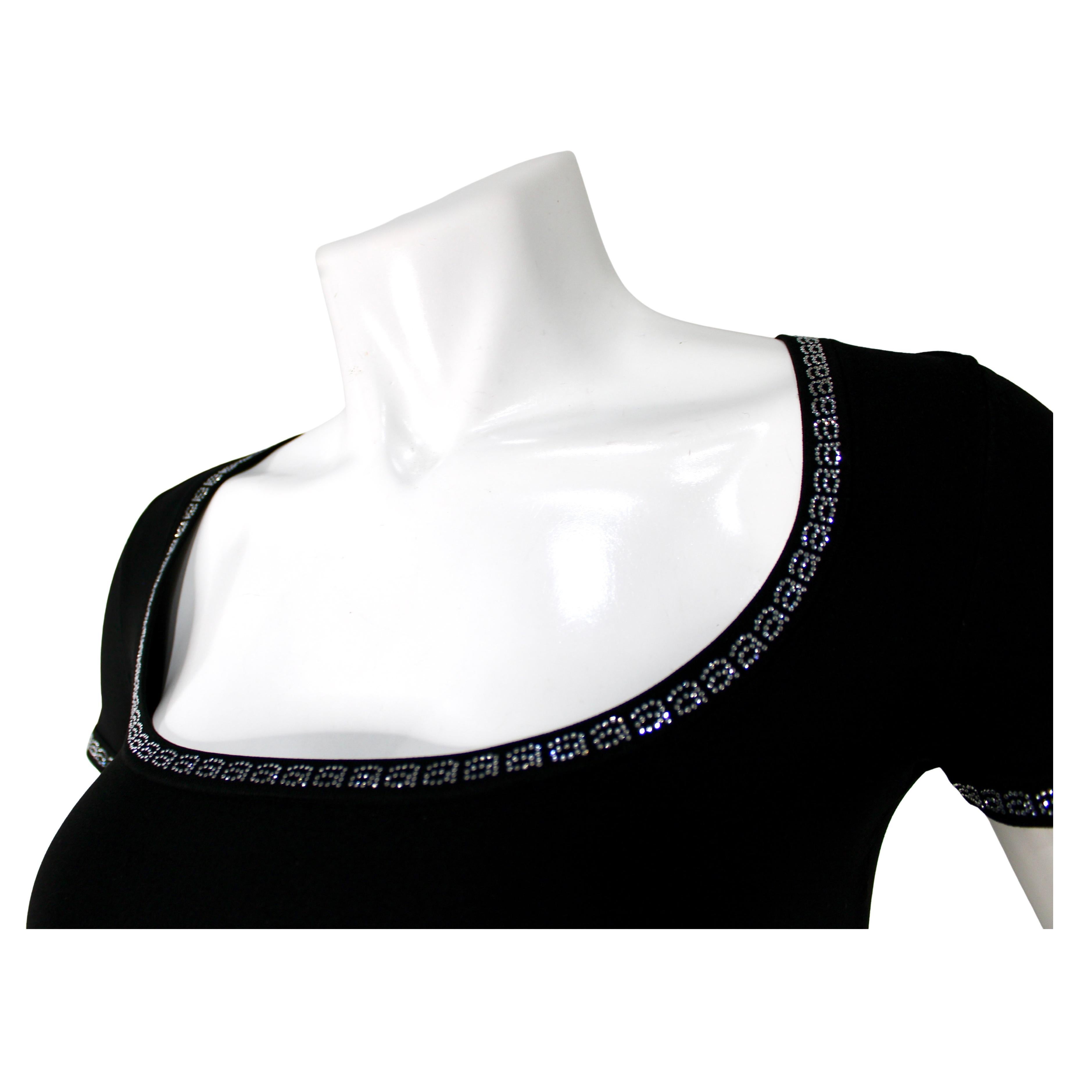 L'Alexander Wang Black Logo Rhinestone Trim Crop Top è un capo audace e contemporaneo che incarna lo streetwear moderno con un tocco di dettagli di lusso. Fabrice in tessuto nero di alta qualità, questo crop top presenta l'iconico logo di Alexander