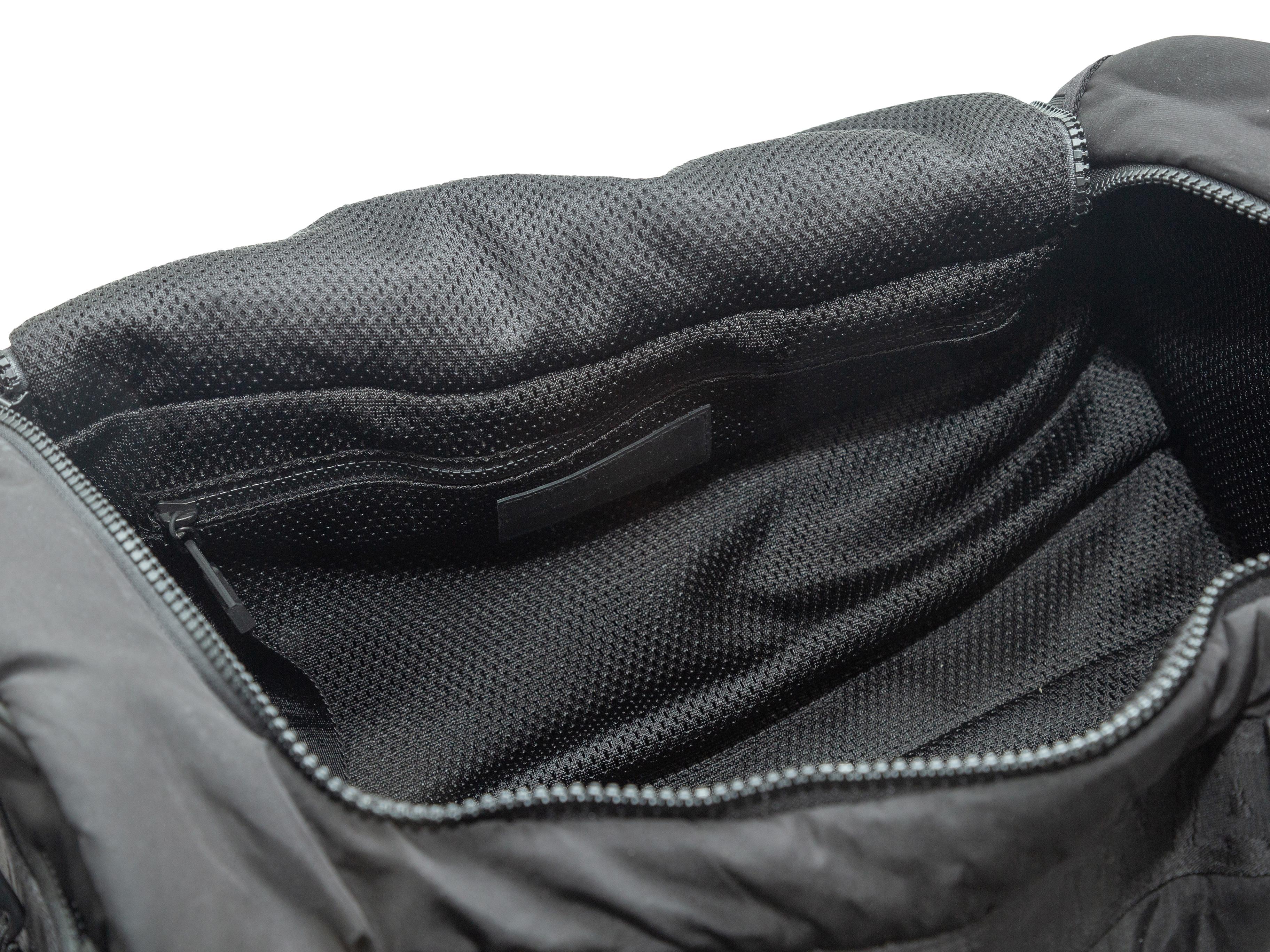 Product Details: Black nylon duffel bag by Alexander Wang. Interior zip pocket. Dual handles. Detachable shoulder strap. Zip closure at top. 17