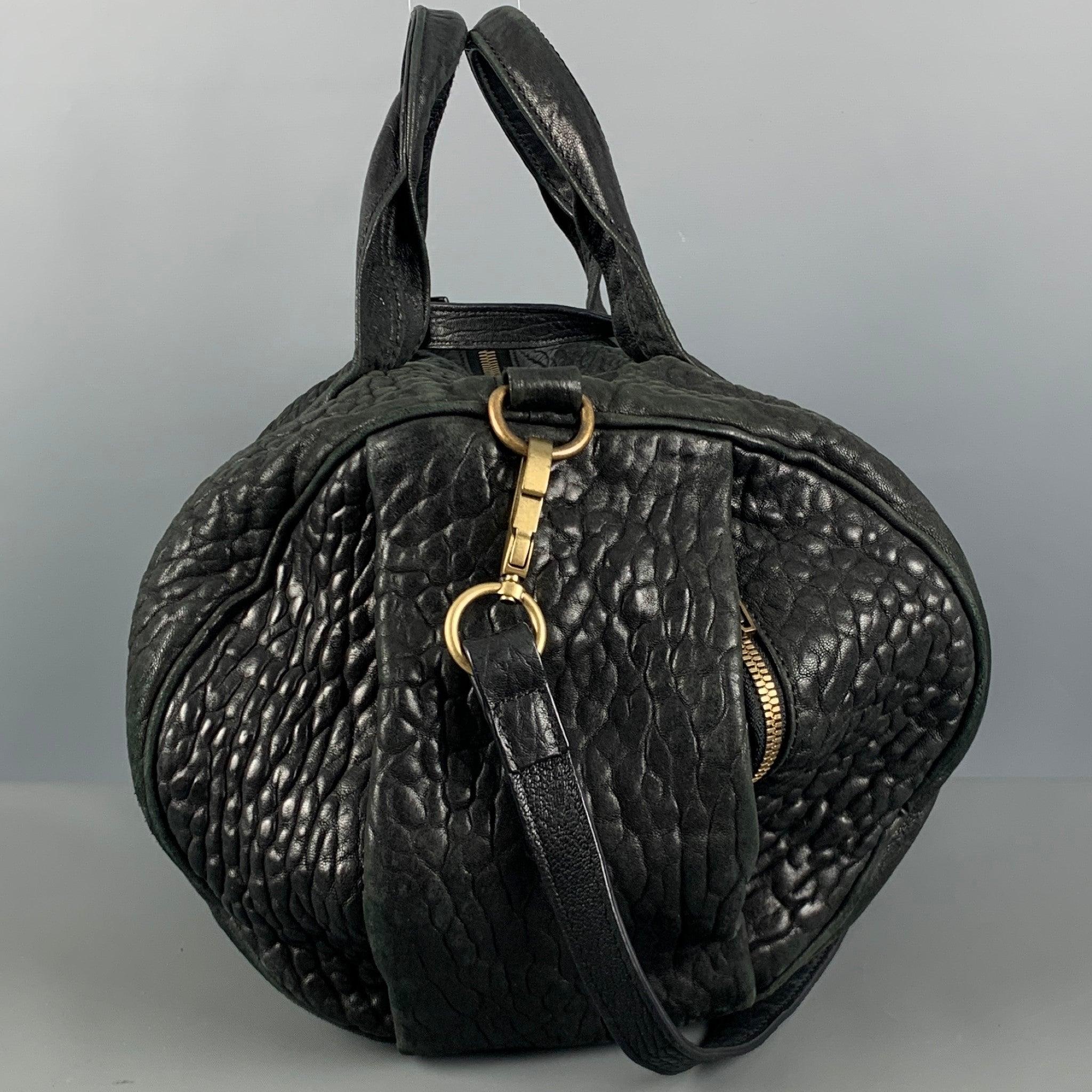 ALEXANDER WANG handbag comes in a black embossed leather featuring shoulder leather straps, copper tone hardware, inner pockets, and a zipper closure.Good Pre-Owned Condition. Moderate Signs of Wear. 

Measurements: 
  Length: 13 inches Width: 4.5