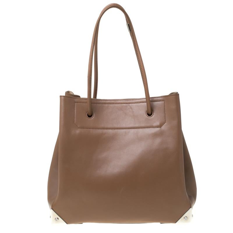 Indulge in Alexander Wang's iconic styles with this Prisma tote. Made of brown leather, the bag features dual top handles and metal guards securing the edges while making it both lovely to look at and safe. It has a roomy leather-lined interior with