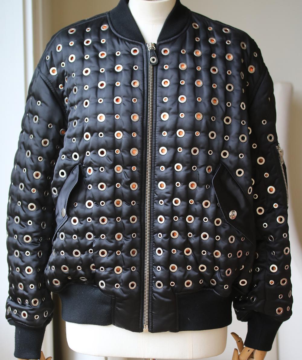 Alexander Wang black bomber jacket. Shell and leather. Zipped sleeve pocket, eyelet embellishments, leather and elasticated trims, fully lined. Zip fastening through front. 100% nylon; trim1: 78% wool, 20% polyester, 2% spandex; trim2: 100% leather