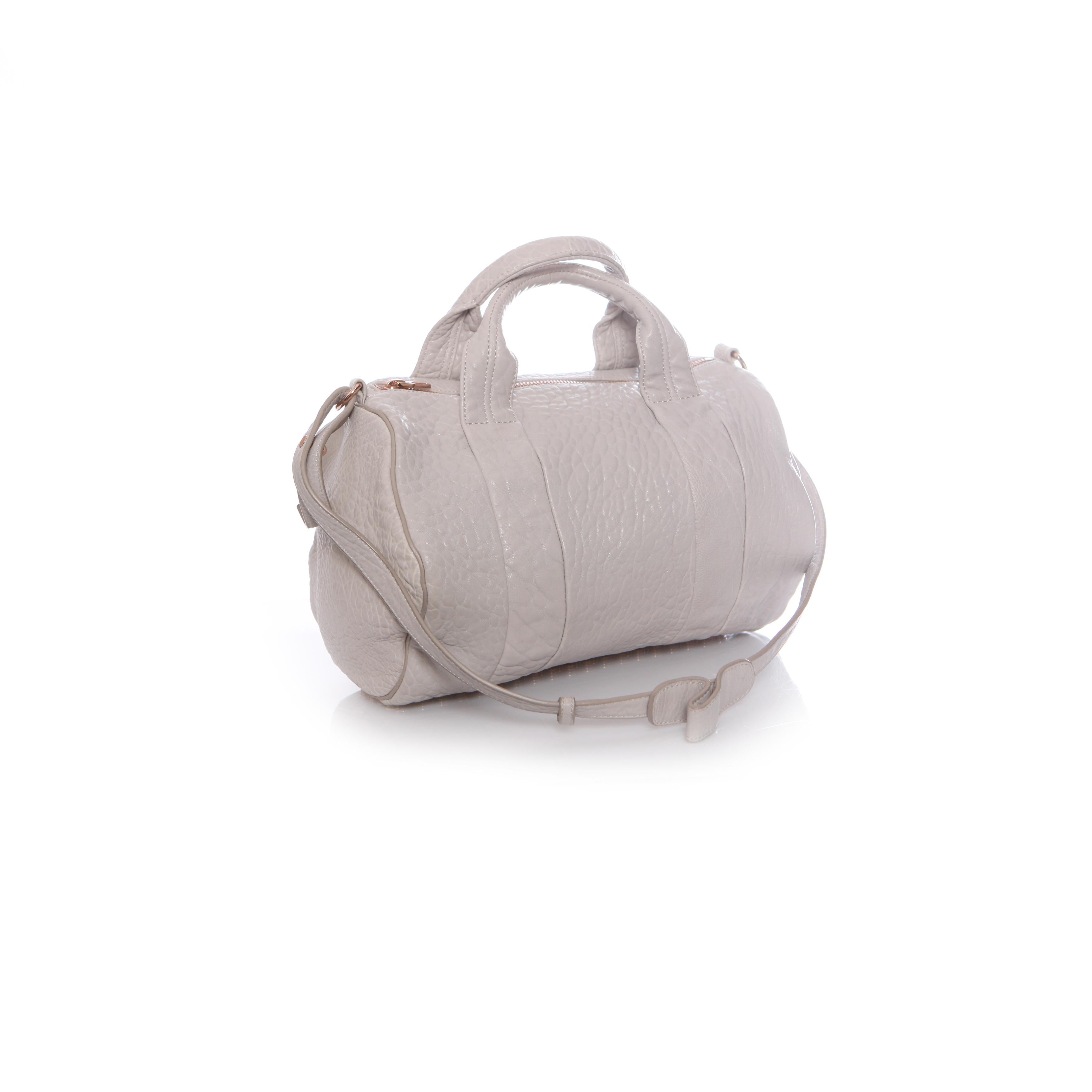 Alexander Wang, light grey rockie bag with rose coloured studs. This product has been worn only a few times and is in very good condition.

• CONDITION: good condition

• MEASUREMENTS: height 32 cm, width 32 cm, depth 11 cm, height handle 9 cm (from