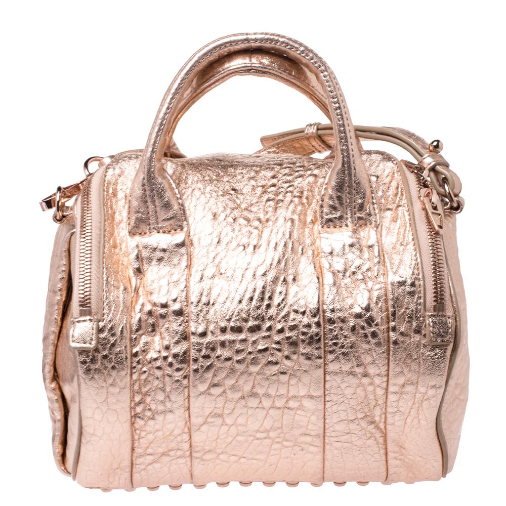 Creations like this Rocco Duffle bag by Alexander Wang never go out of style. This metallic bag is crafted from textured leather and it features dual handles and rose gold-tone hardware. The top zipper opens to a nylon interior sized to carry your