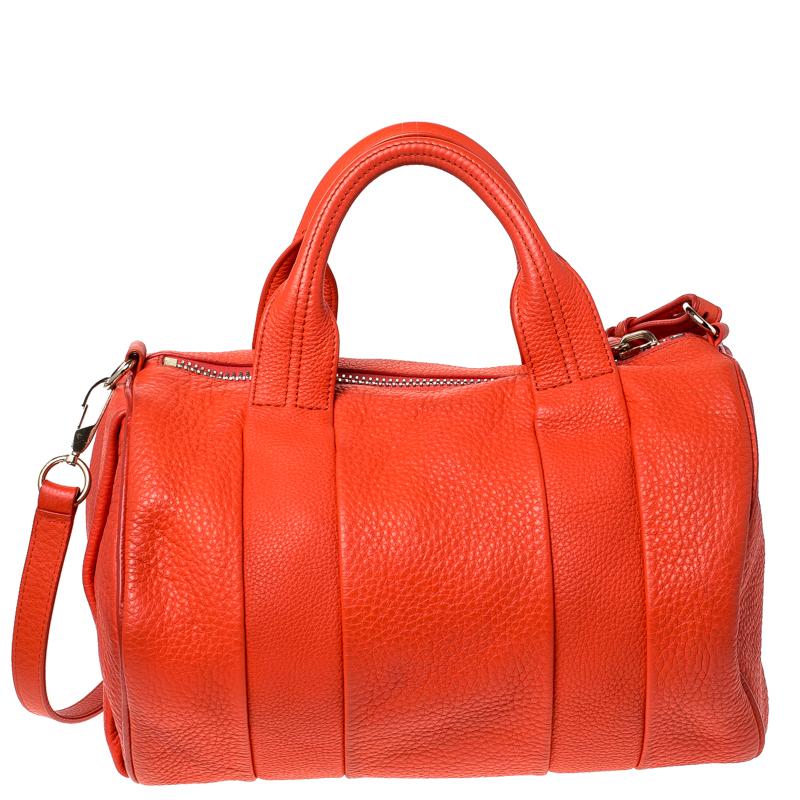 Creations like this Rocco Duffle bag by Alexander Wang never go out of style. This orange bag is crafted from leather and it features dual handles and silver-tone hardware. The top zipper opens to a fabric interior sized to carry your essentials.