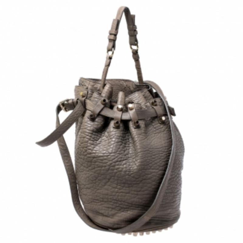 This chic Diego bucket bag from Alexander Wang is not only a symbol of style but also reliability. Crafted from taupe textured leather, the bag features a single top handle, an adjustable shoulder strap and protective metal feet at the bottom. The