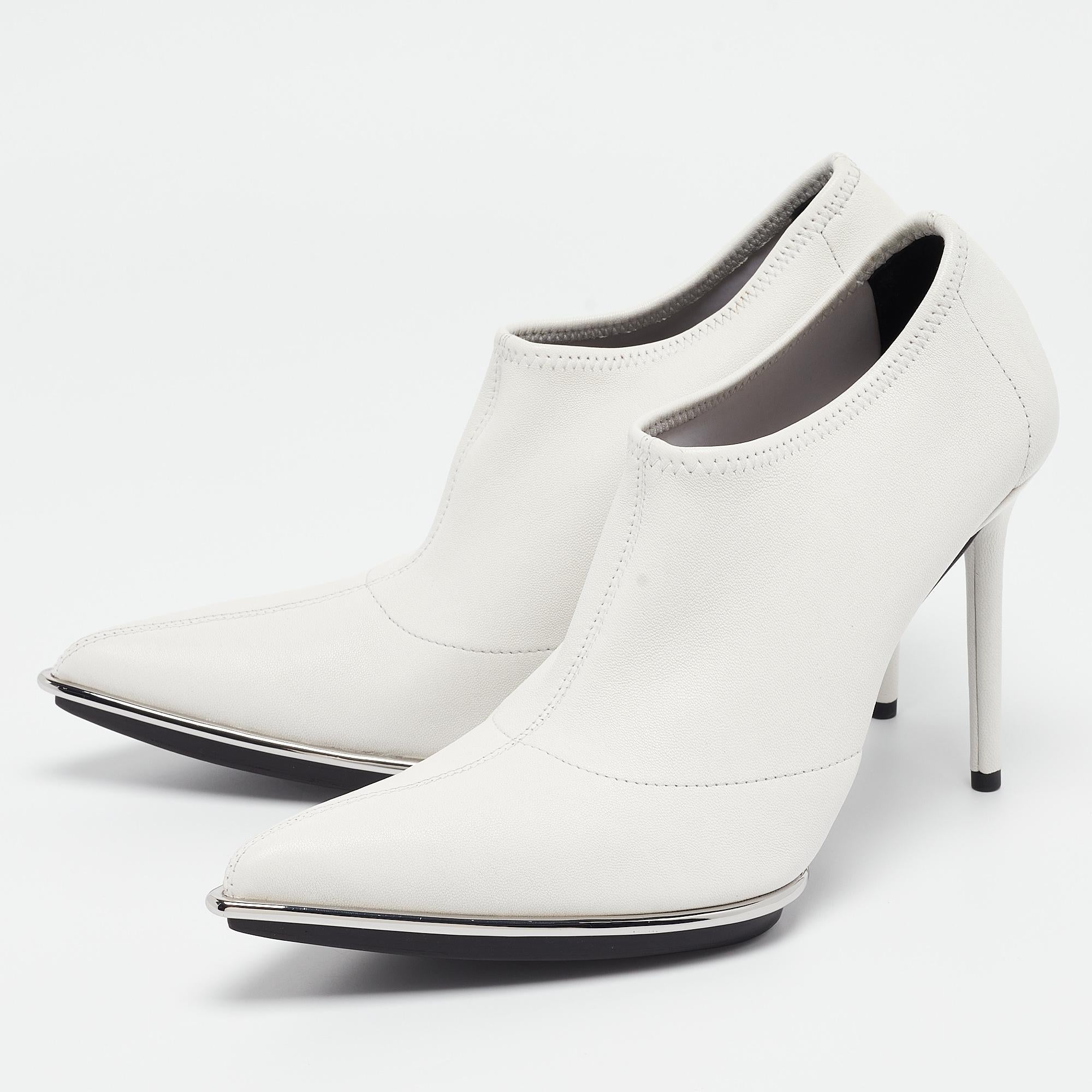 Crafted by Alexander Wang, the Cara Booties exude contemporary chic. Their sleek silhouette boasts supple white leather, complemented by a pointed toe and a sturdy block heel for comfort and style. Perfect for adding a touch of modern elegance to
