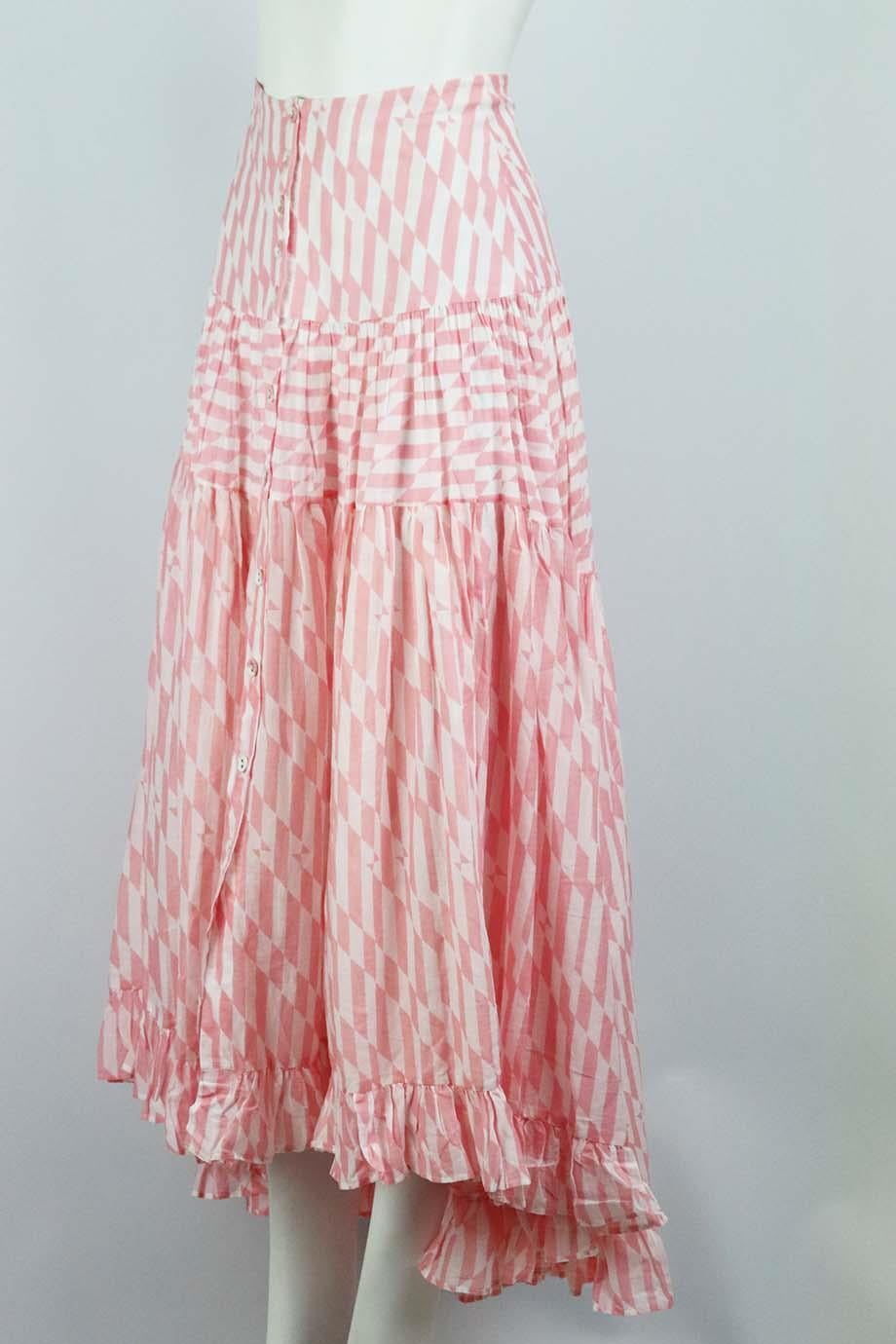 This ‘Penelope’ maxi skirt by Alexandra Miro is made from crisp cotton in a pink geometric print with a wide high waistband, full tiered skirt finished with a ruffle hem. Pink and white cotton. Button fastening at front. 100% Cotton. Size: Medium