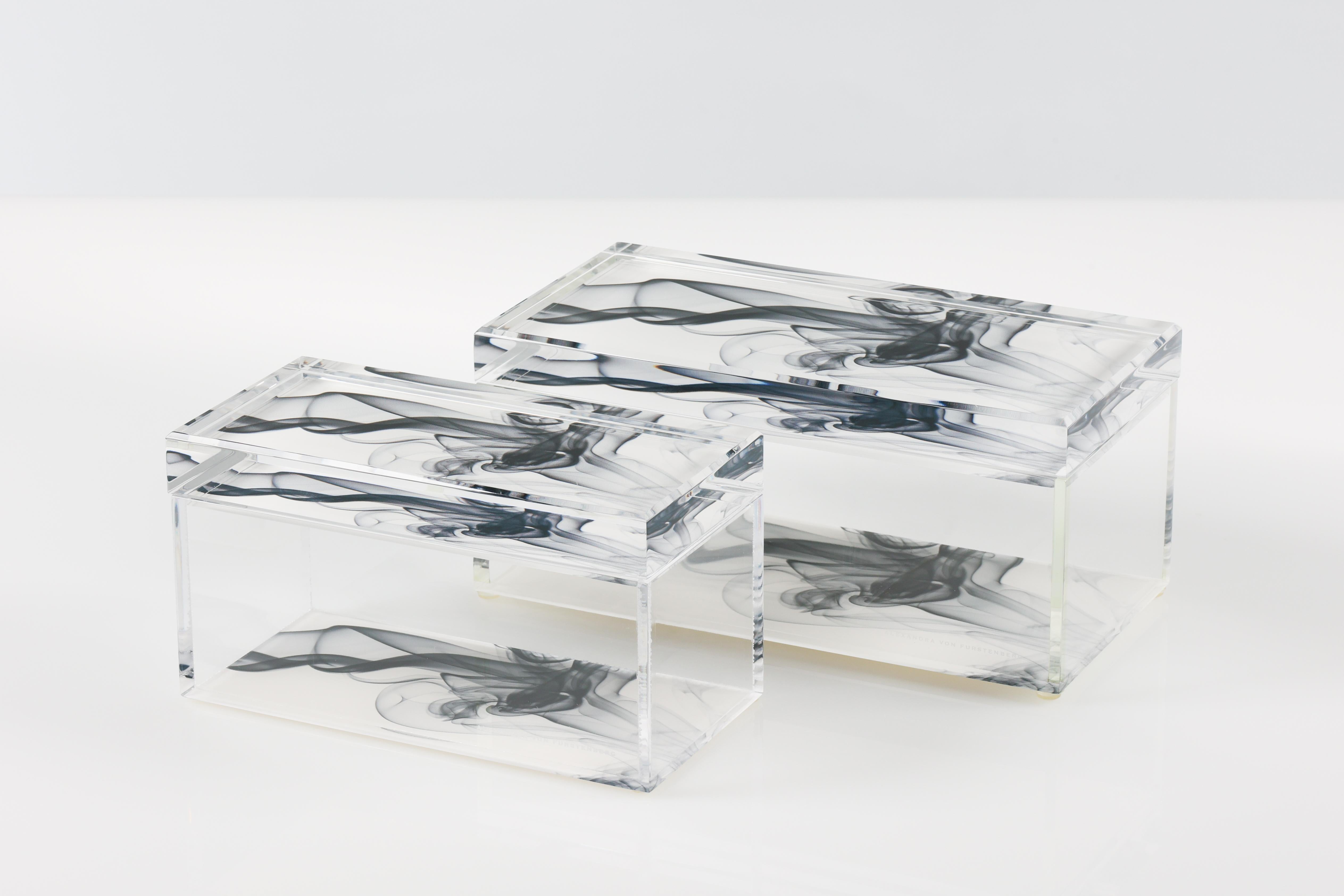Añade un atrevido toque de glamour moderno a tu espacio con esta caja acrílica para tesoros de Alexandra Von Furstenberg, con un llamativo estampado Black Smoke en blanco y negro. Fabricada en Lucite de alta calidad, esta elegante caja decorativa es