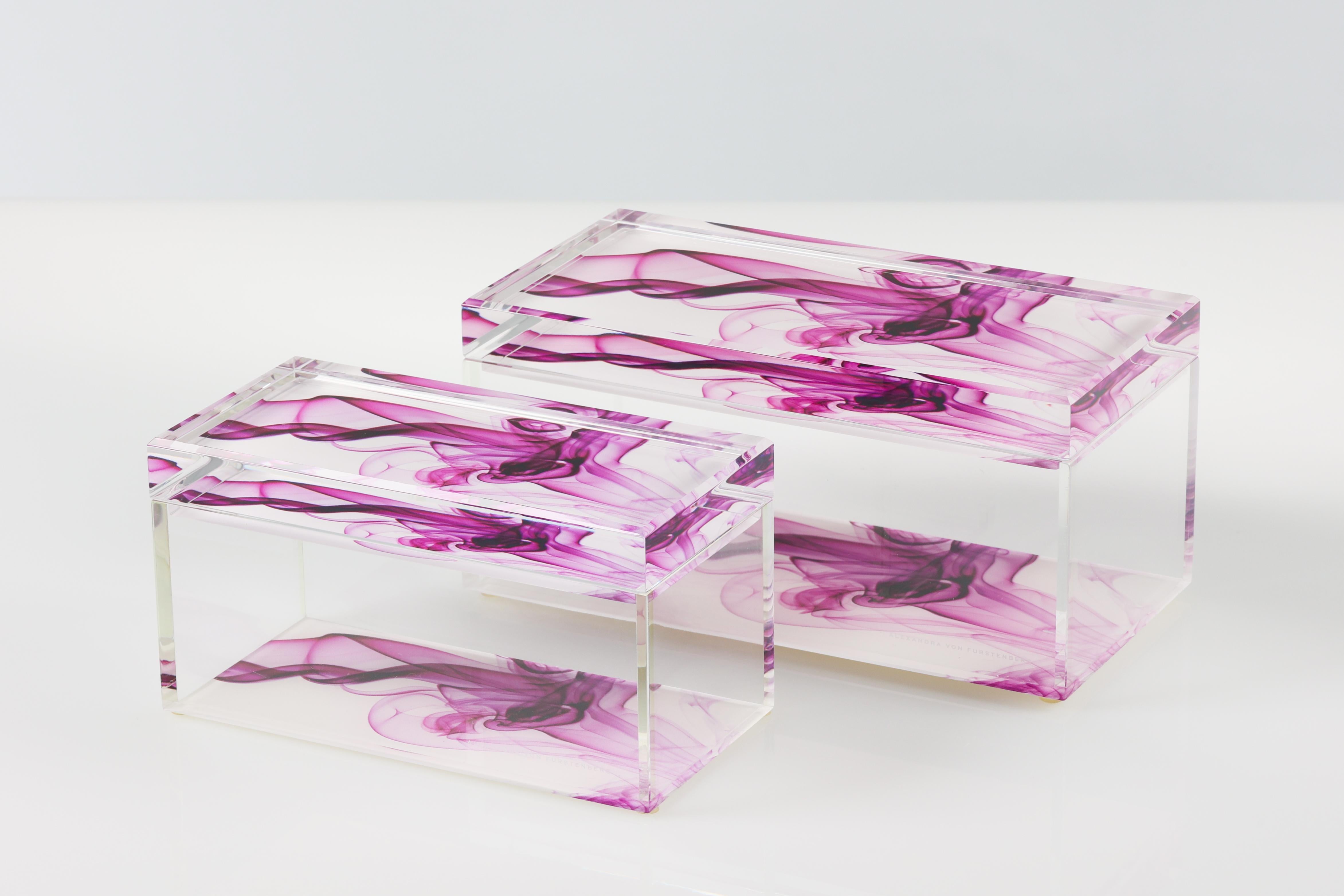 Añade un atrevido toque de glamour moderno a tu espacio con esta caja acrílica para tesoros de Alexandra Von Furstenberg, con un llamativo Magenta Smoke morado y blanco. Fabricada en Lucite de alta calidad, esta elegante caja decorativa es perfecta