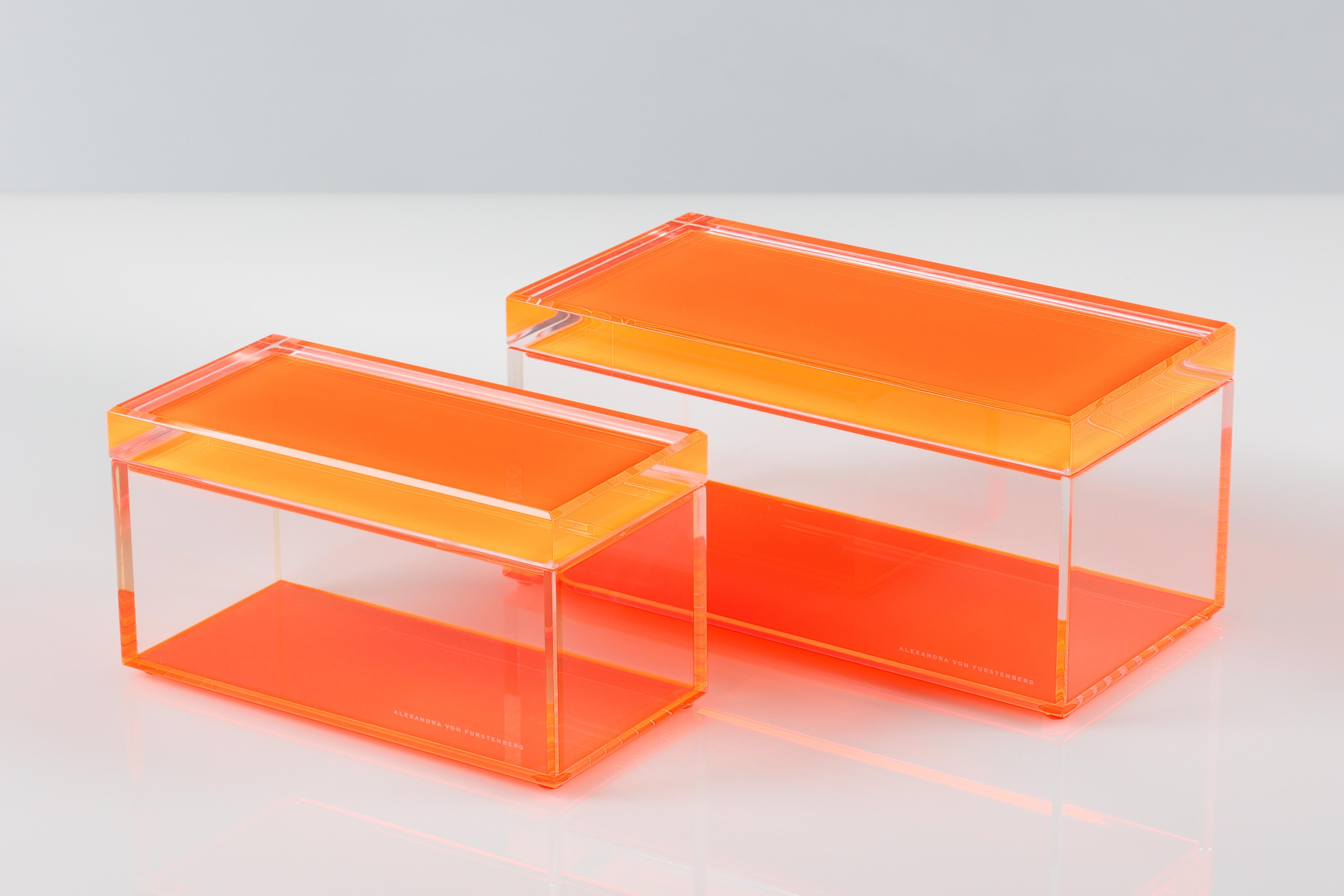 Añade un atrevido toque de glamour moderno a tu espacio con esta caja acrílica para tesoros de Alexandra Von Furstenberg, con un llamativo color naranja. Fabricada en Lucite de alta calidad, esta elegante caja decorativa es perfecta para guardar
