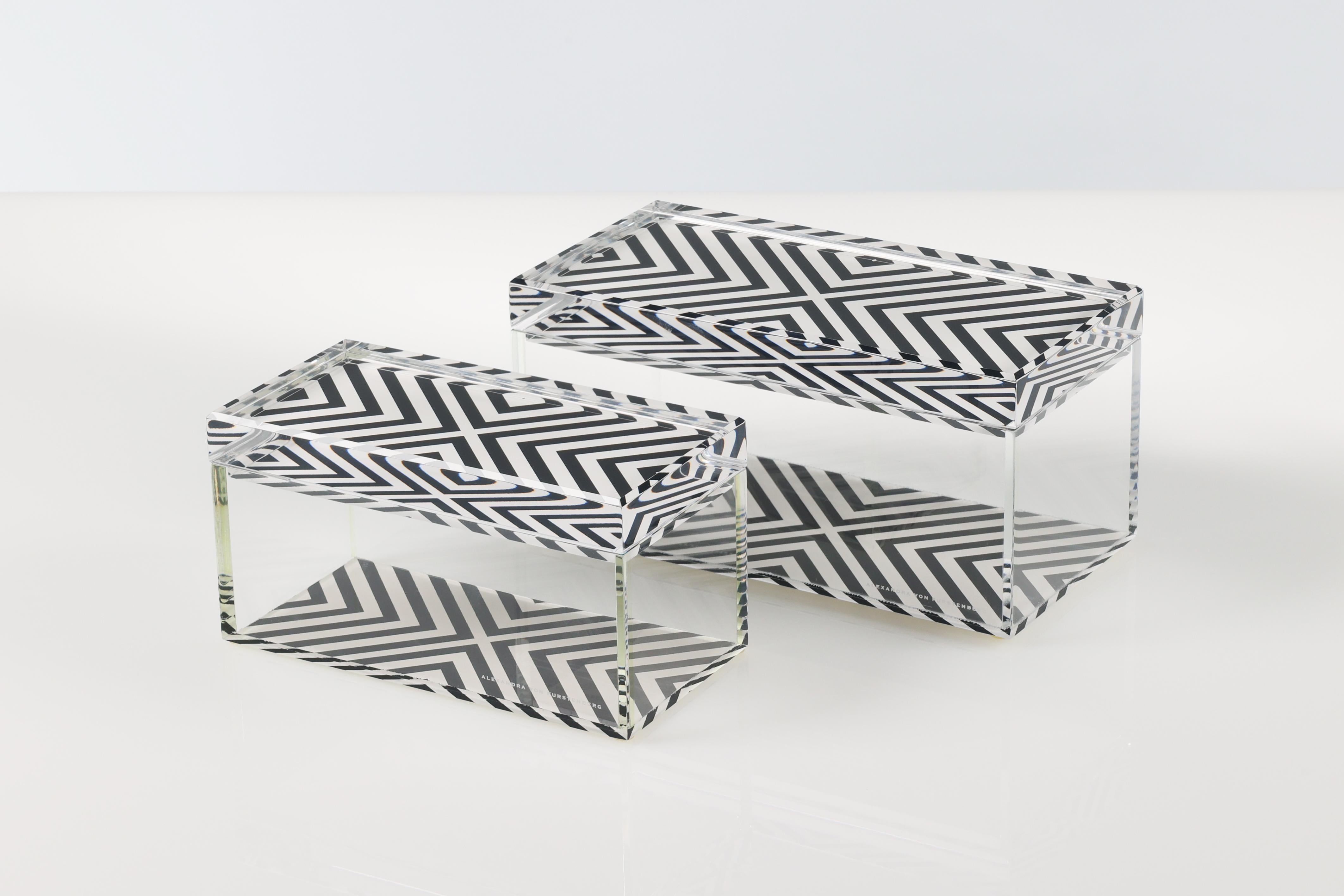 Add a bold pop of modern glamour to your space with this acrylic treasure box by Alexandra Von Furstenberg, featuring a striking black and white X print. Made from high-quality Lucite, this chic decorative storage box is perfect for holding jewelry,
