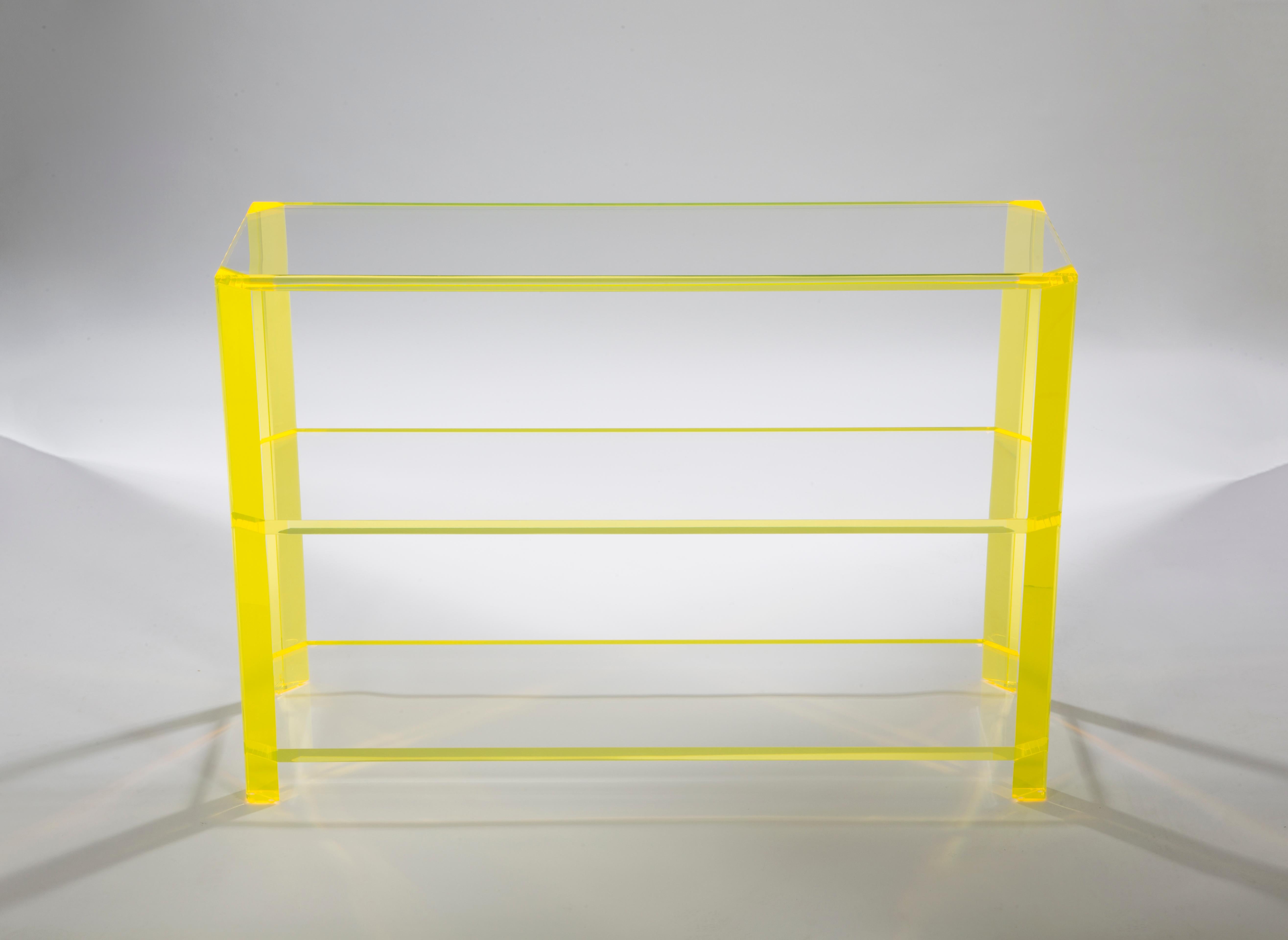 The Alexandra Von Furstenberg Gangster Console Table in yellow and clear acrylic is elegant and sleek. Versatile in design, it can also serve as a bookshelf or buffet table. With its bright pop of color and clean lines, this Lucite furniture piece
