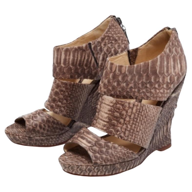 Incornicia i tuoi piedi con questi sandali con zeppa di Alexandre Birman. Realizzate in pelle di pitone, le scarpe sono perfette con orli corti, midi e maxi.