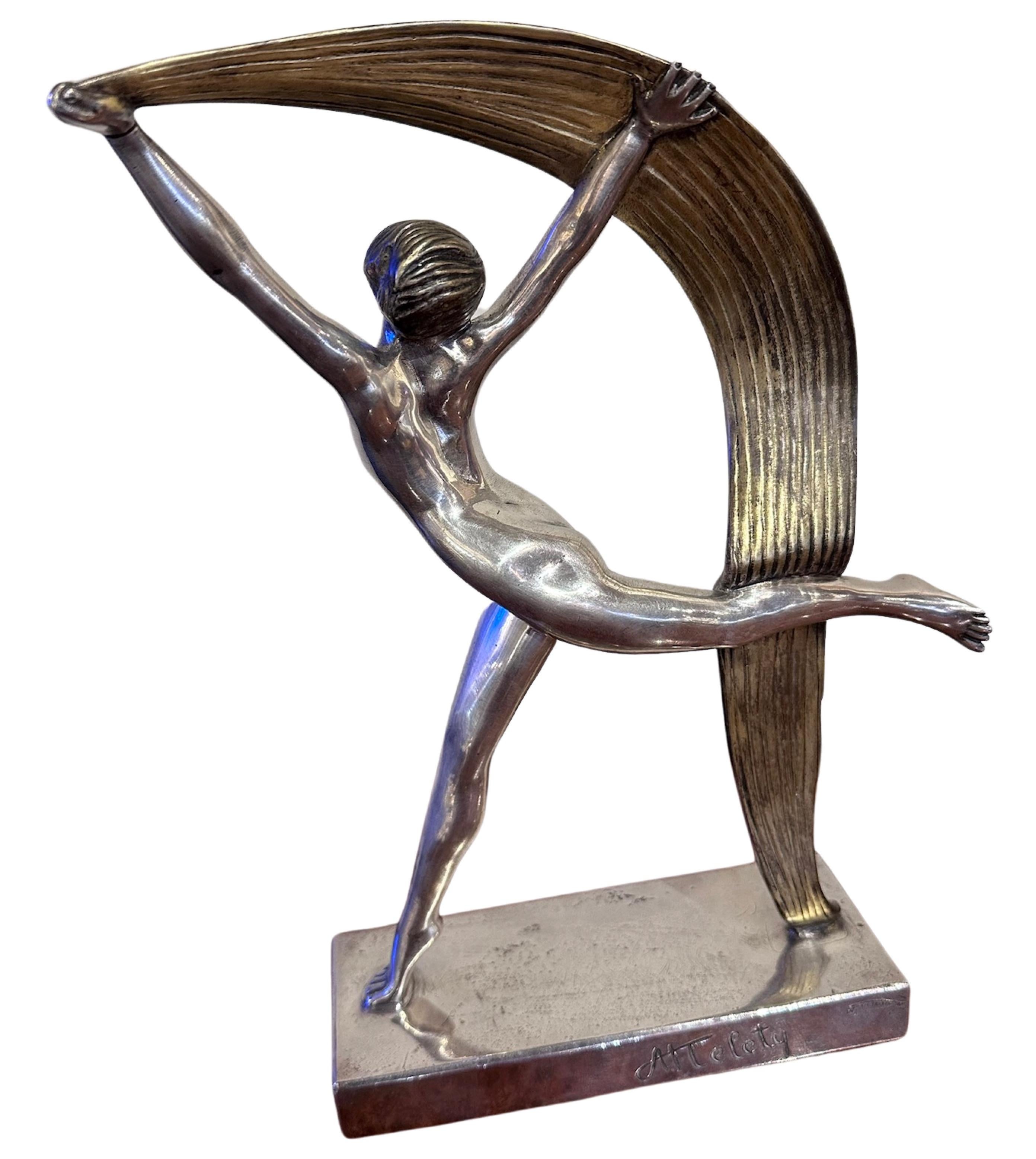 An Art Deco Bronze Scarf Dancer by Alexandre Kéléty created in France in1925 . It depicts a dancer holding aloft a stylized scarf, silver-plated and gilded, mounted on a silvered bronze base. This silver-plated and gilded bronze sculpture is a