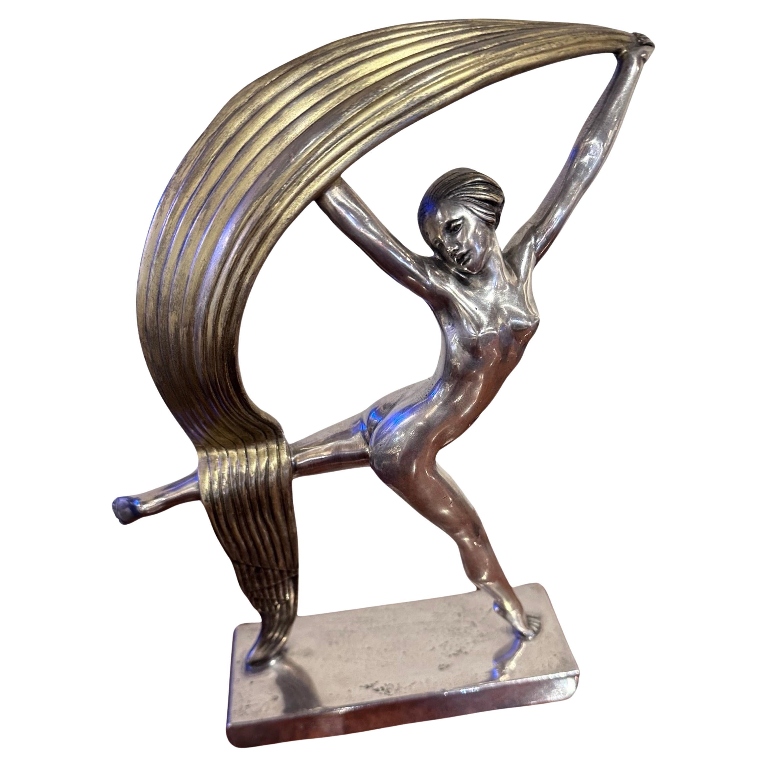 An Art Deco Bronze Scarf Dancer by Alexandre Kéléty, created in France in 1925, depicts a dancer holding a stylized silver-plated and gilded scarf mounted on a silvered bronze base. This silver-plated and gilded bronze sculpture is a symphony of