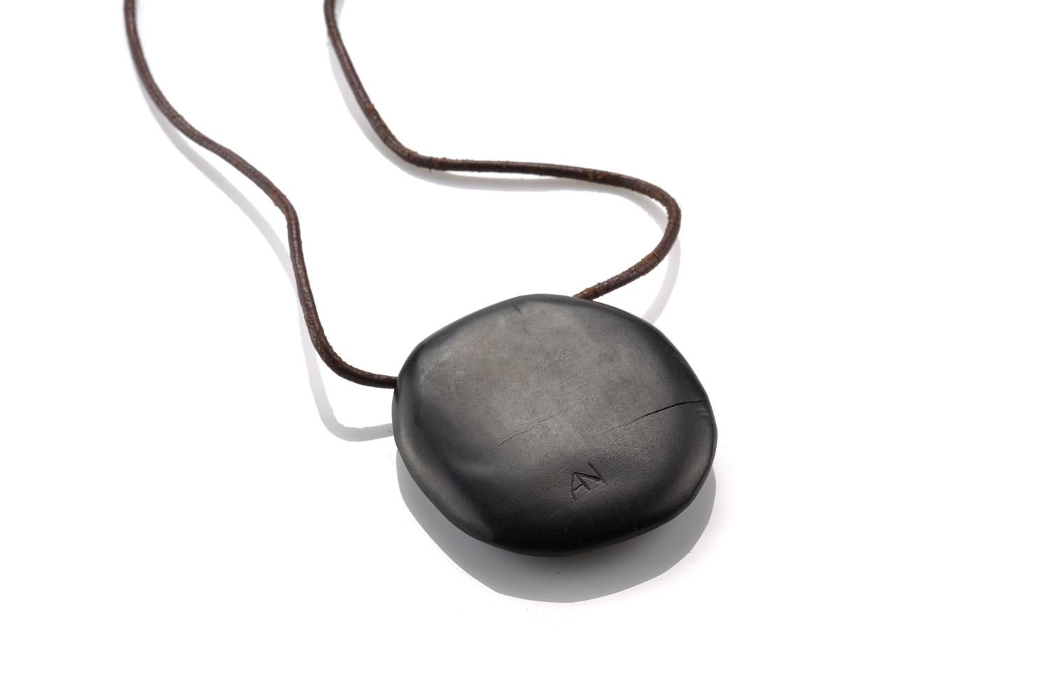 Alexandre Noll pendant, made from ebony, gold inlay, leather cord

France, circa 1955. Measures: 2.25