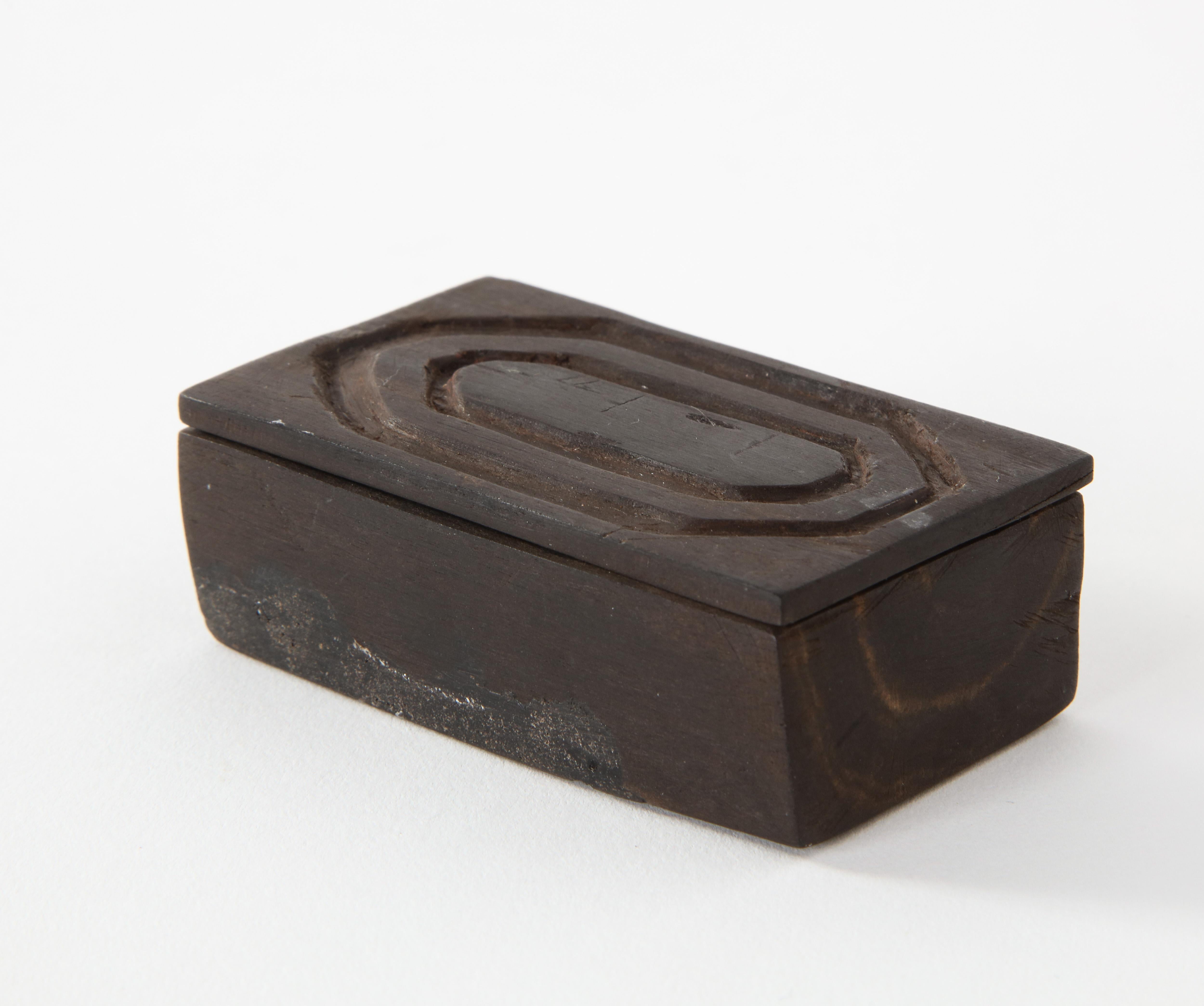 A small carved wood box in the style of Alexandre Noll. France, circa 1950. Top slides open.