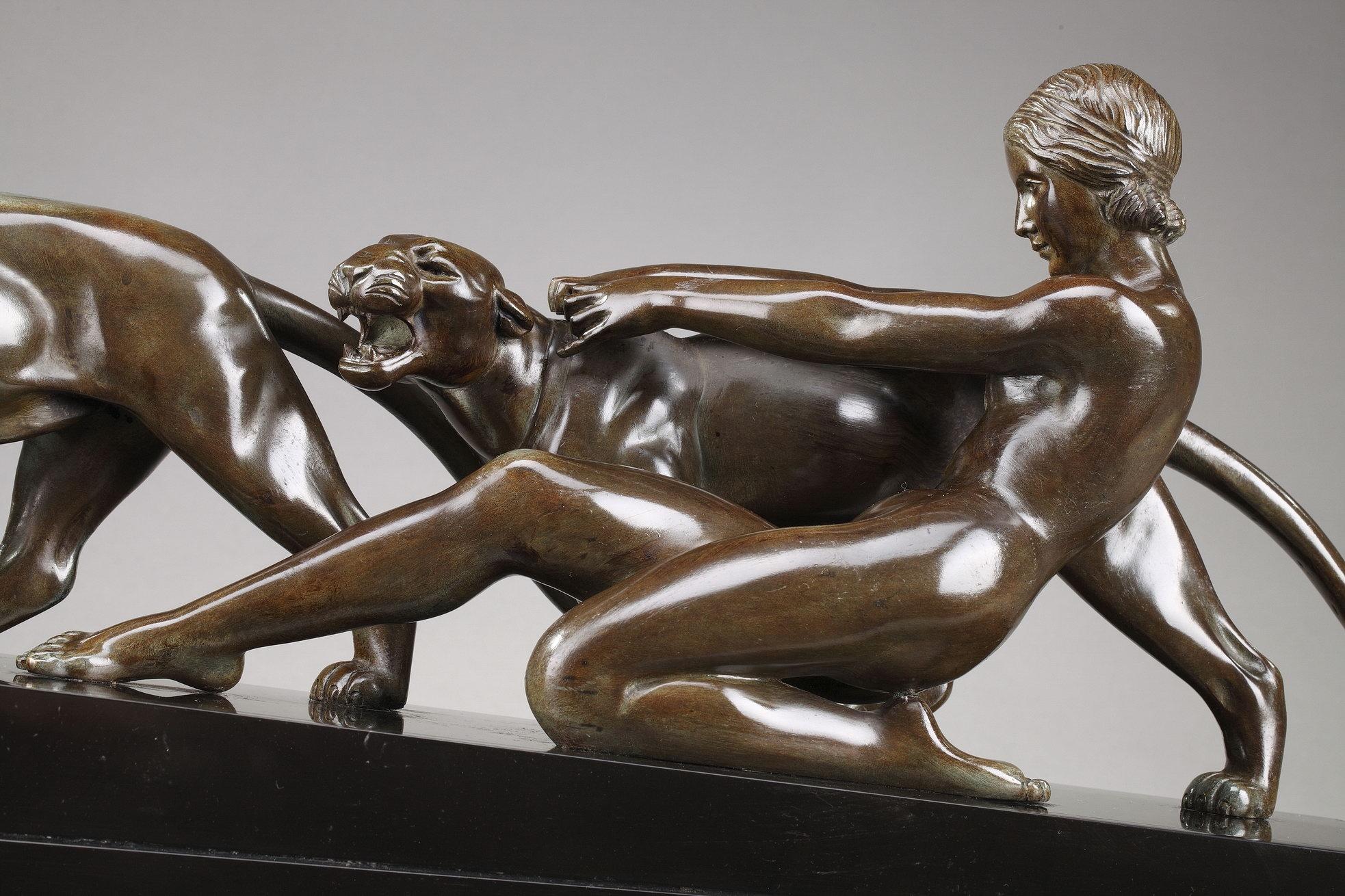 Art-Deco-Gruppe aus Bronze mit brauner Patina mit einer Frau:: die einen Panther hält. Die beiden Tiere und die Frau stehen auf einem Sockel aus schwarzem Marmor. Unterschrieben auf der Terrasse: Ouline (für Alexandre Ouline). Alexandre Ouline war