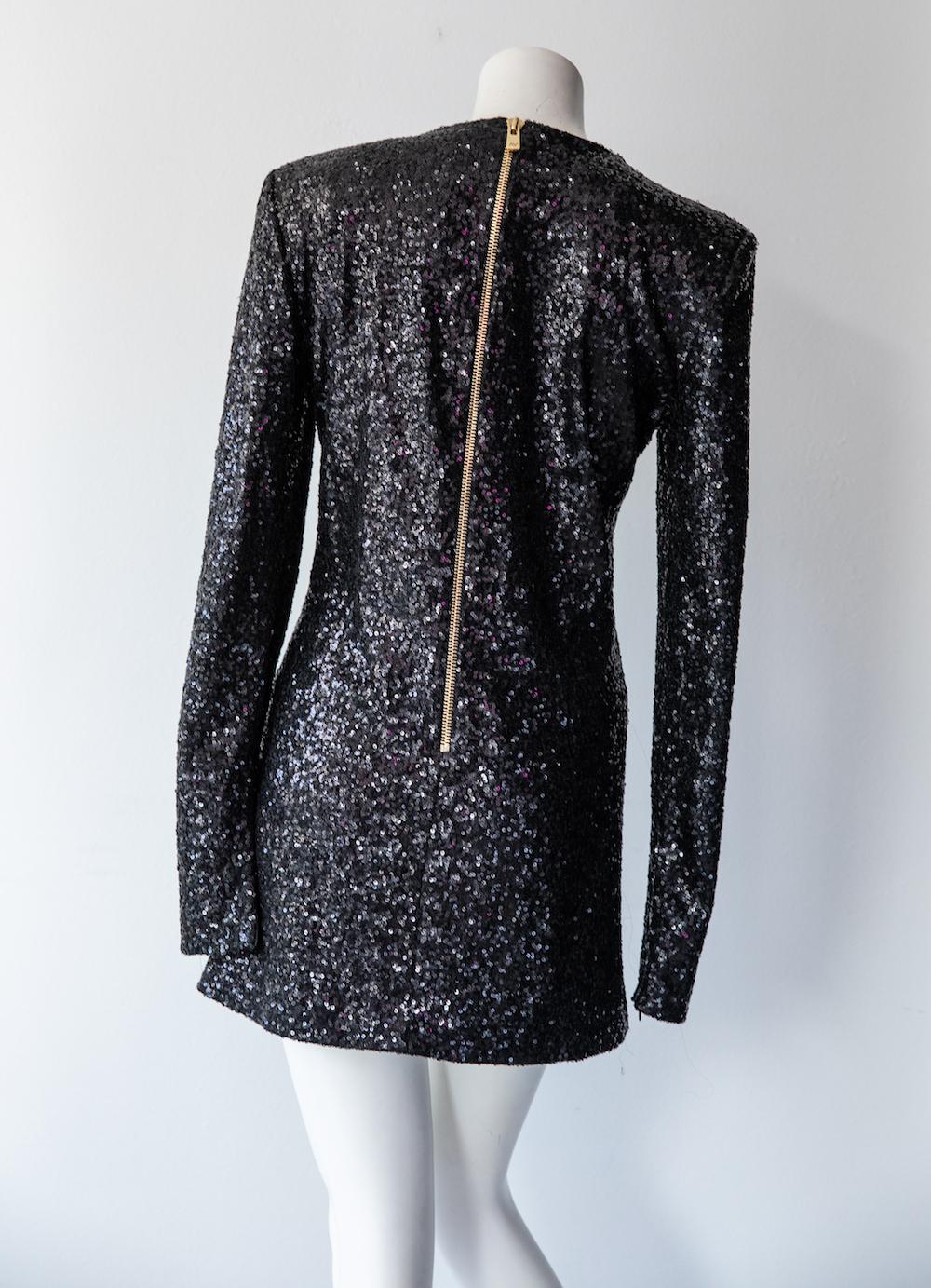 Long sleeve cocktail dress by designer Alexandre Vauthier for his namesake label. Vauthier designed this structured mini dress before beginning his tenure at Saint Laurent. It features a black mini-sequins all over, with a heavy gold exposed zipper