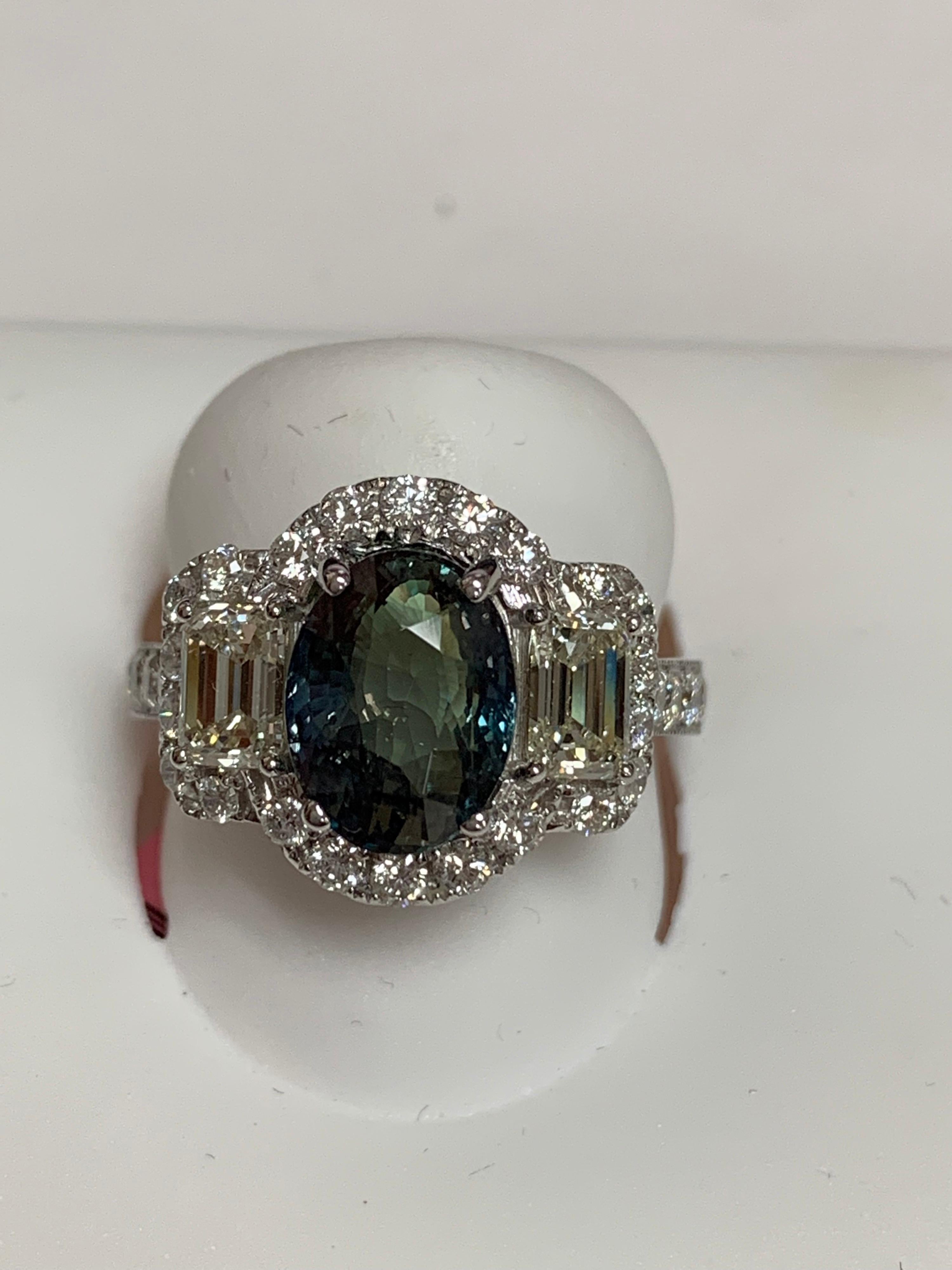 Natural Color change 3.56 Oval Alexandrite set with 1.85 Carat two emerald cut and round diamonds set in 18 Karat white gold is one of a kind handcrafted ring.